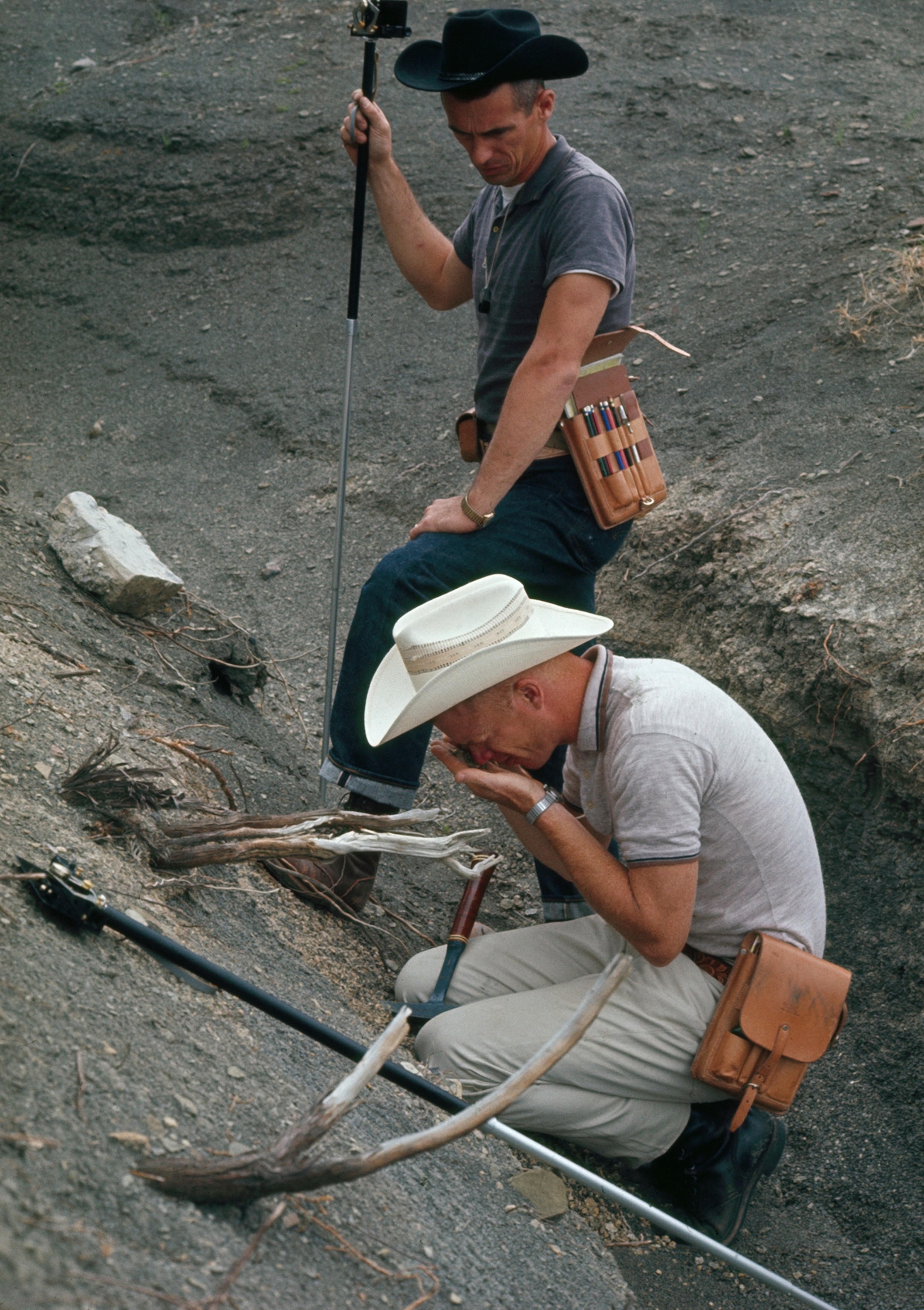 Astronauts study rocks and surveying to prepare for a moon landing.