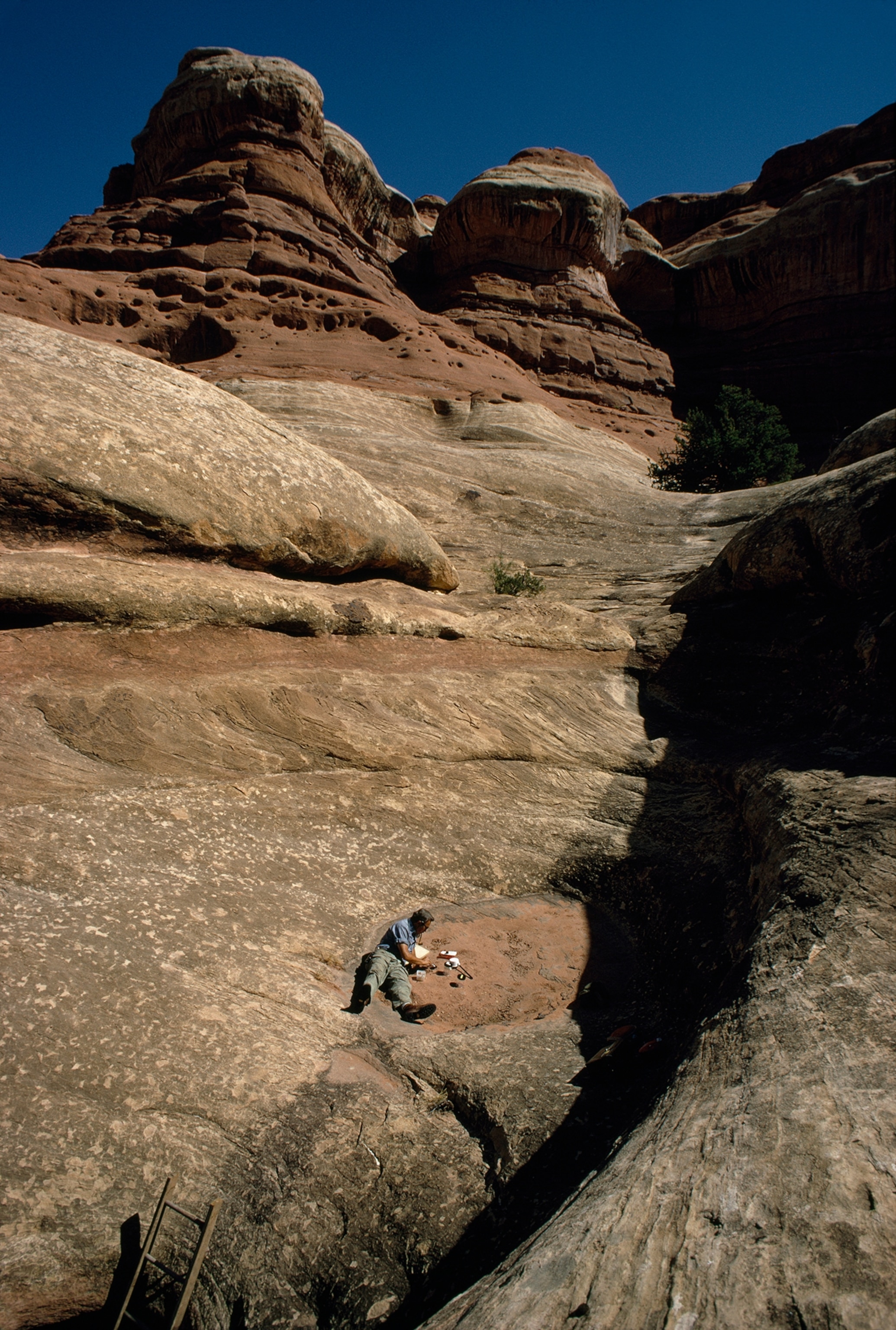 A scientist inspects a dried desert pothole.