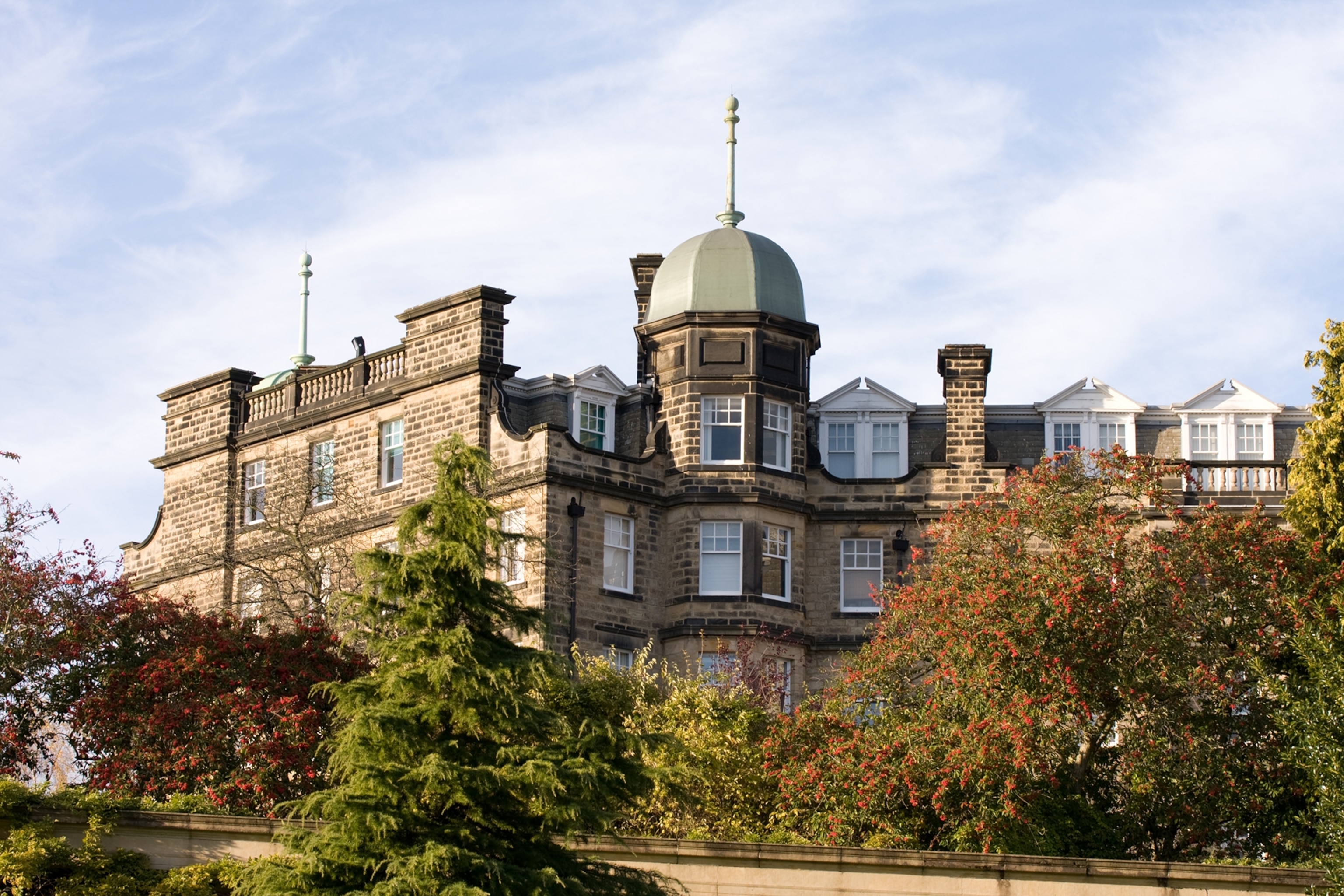 A medieval castle-like fort atop a hill with trees lining the edge.