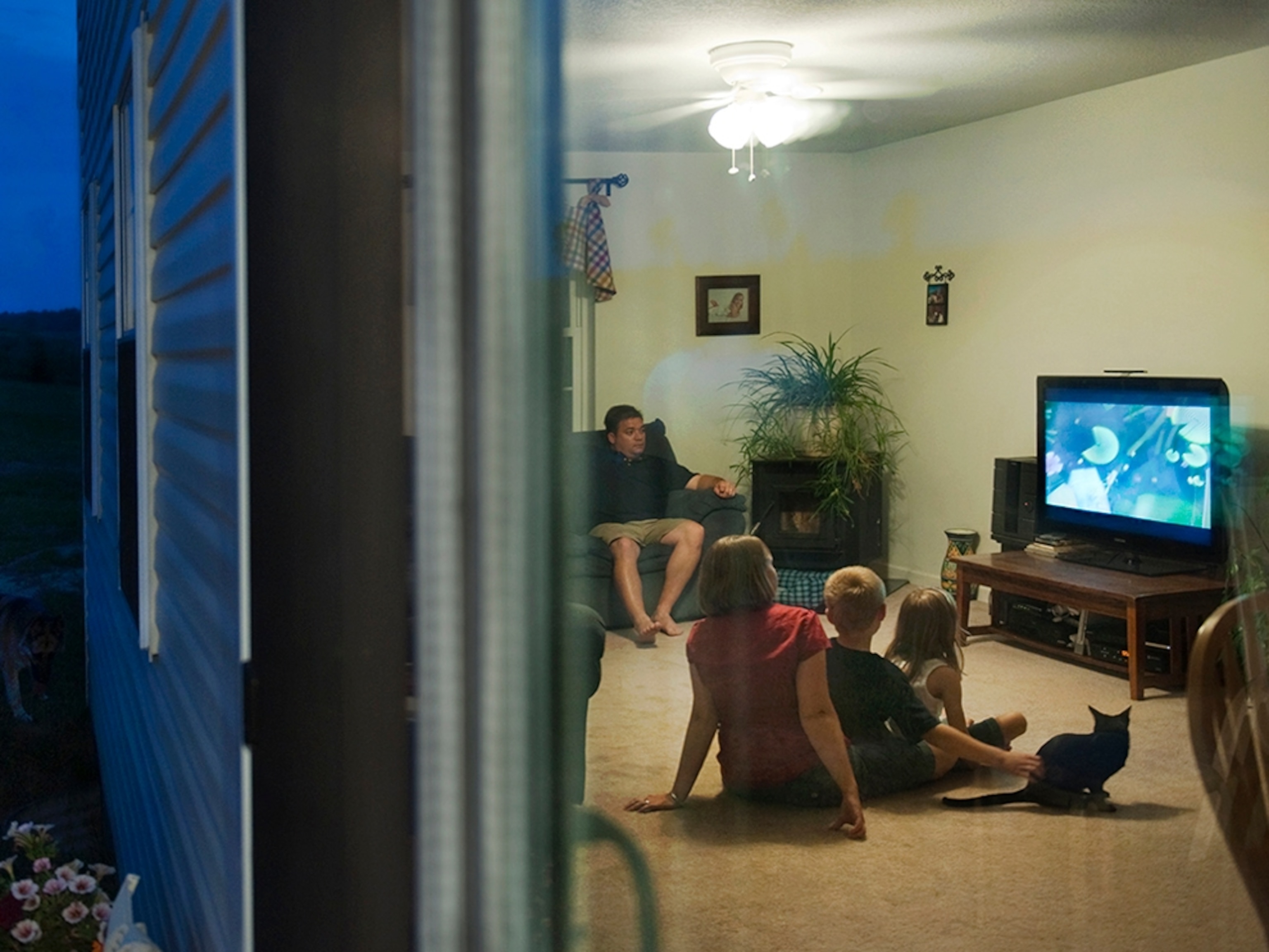 The Hallowich family watches television after dinner.