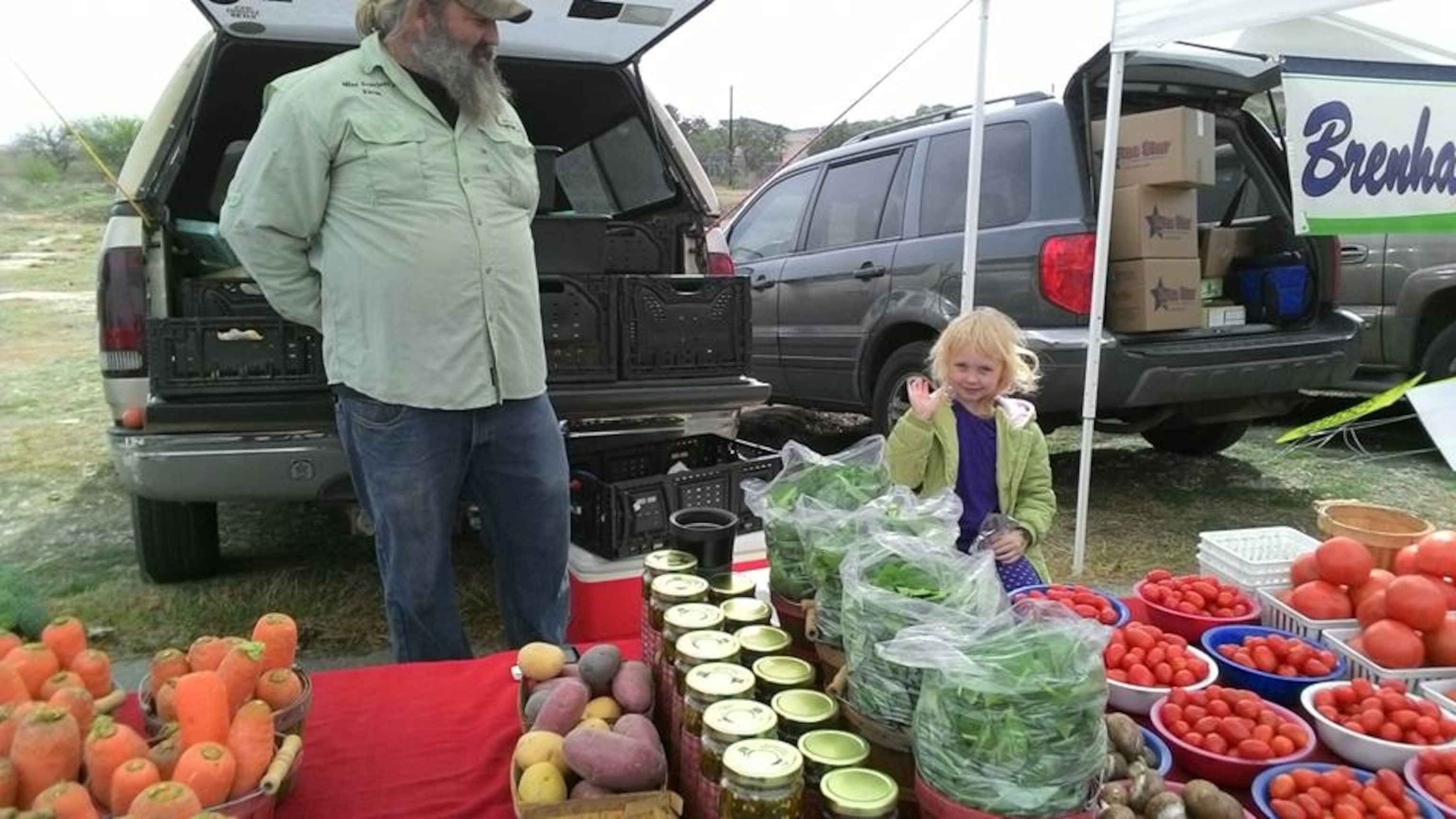 Anthony Micheli and daughter Scarlett stand ready to sell their vegetables at a Texas Farmers Market.