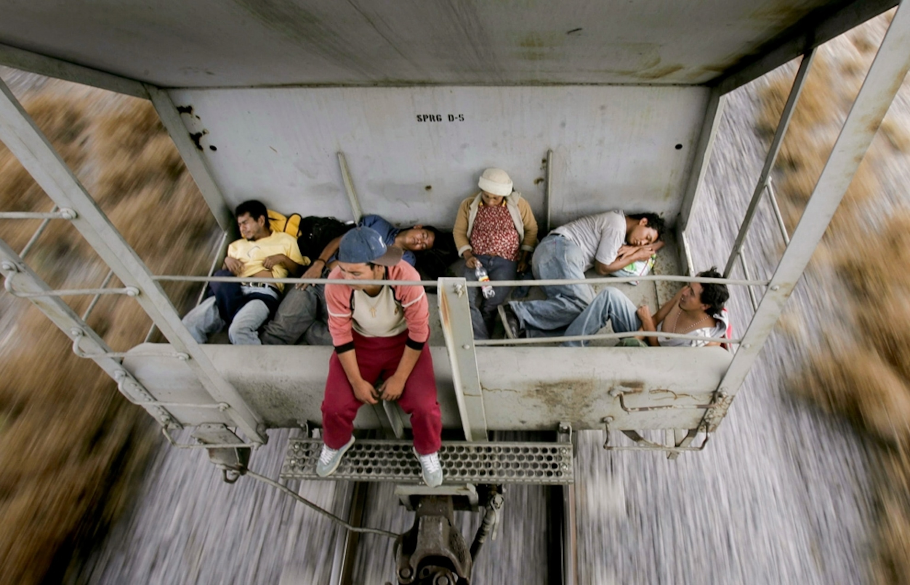 People travel on a cargo train heading towards the border between Mexico and the United States.