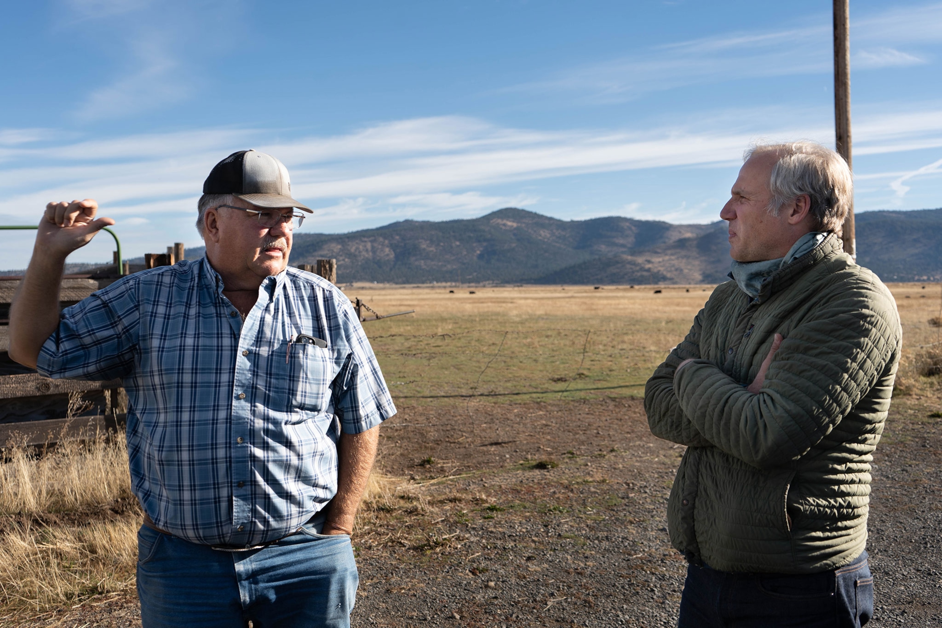 Two men standing in the frame in front of the landscape.