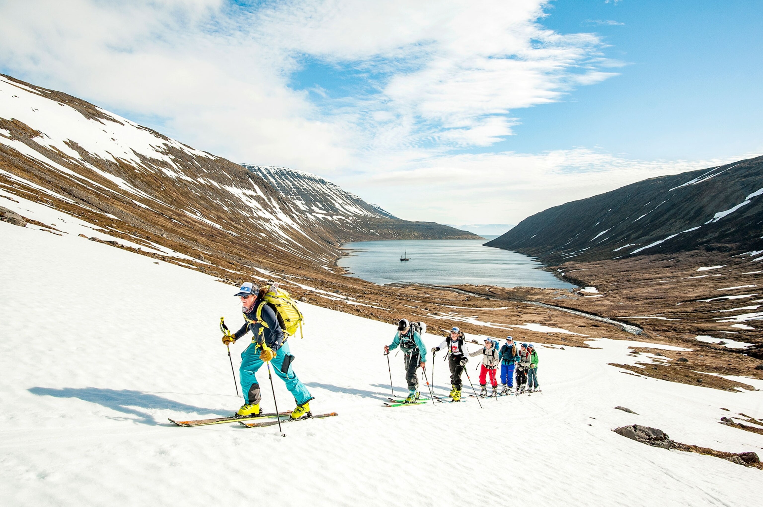 a group of skiers hiking up a hill in Iceland