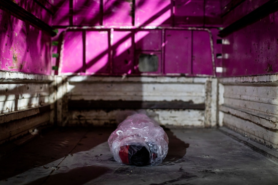 The body of a man who died from COVID-19 lies cocooned in plastic wrap.