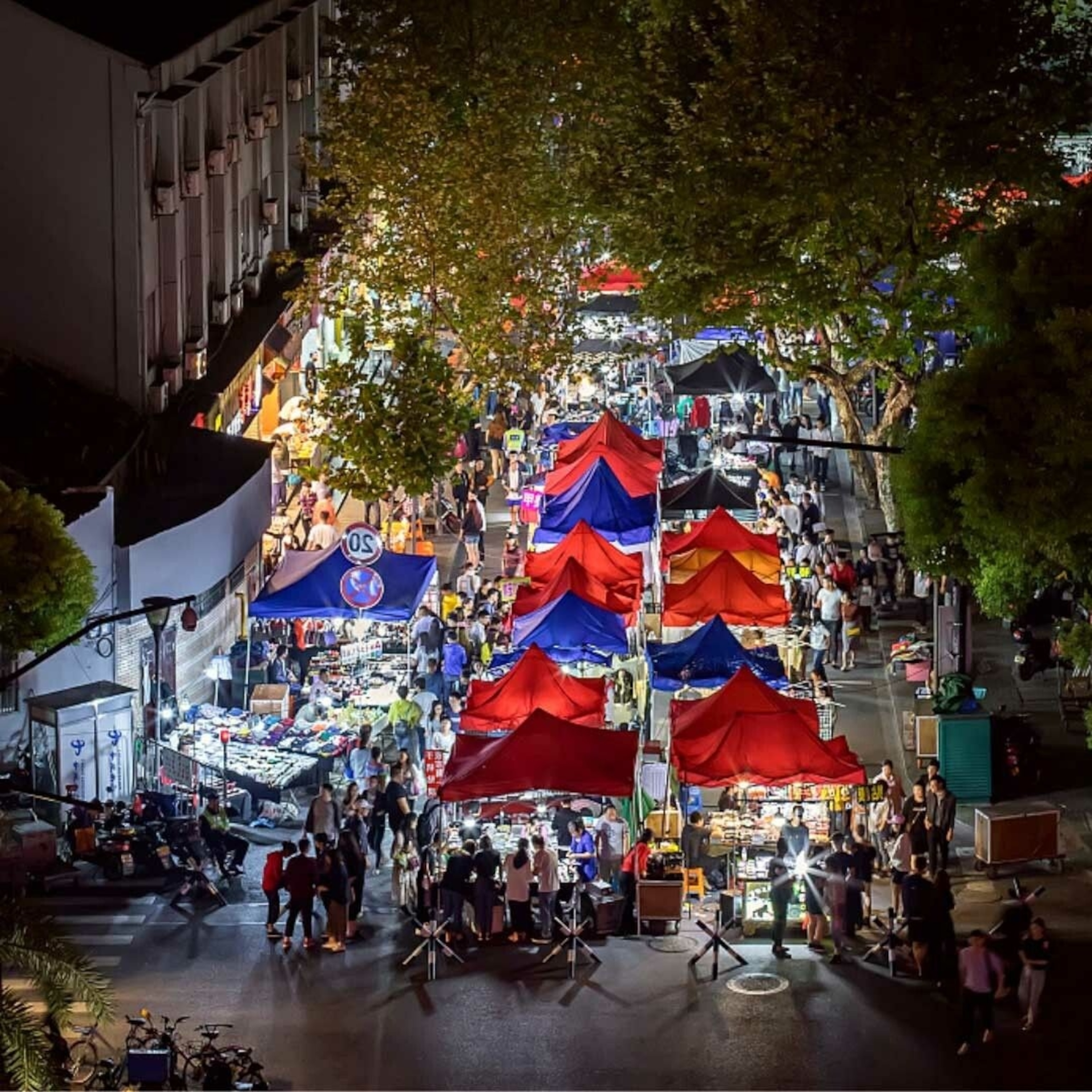 Stalls at the Wushan Night Market, which have red, blue and black tarps for roofs.