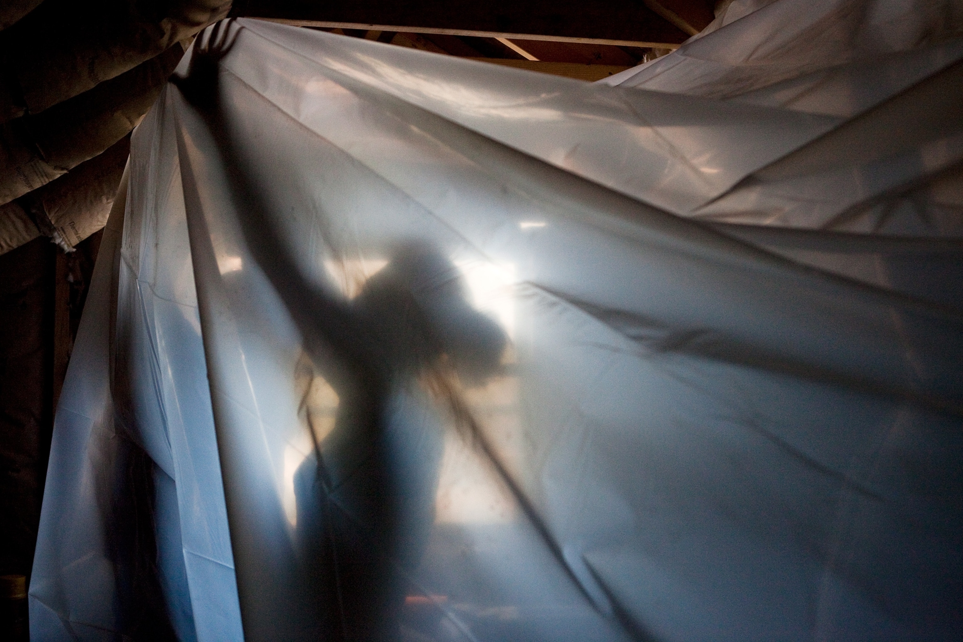 How Joplin Recovered - A woman hangs plastic sheeting in a garage.