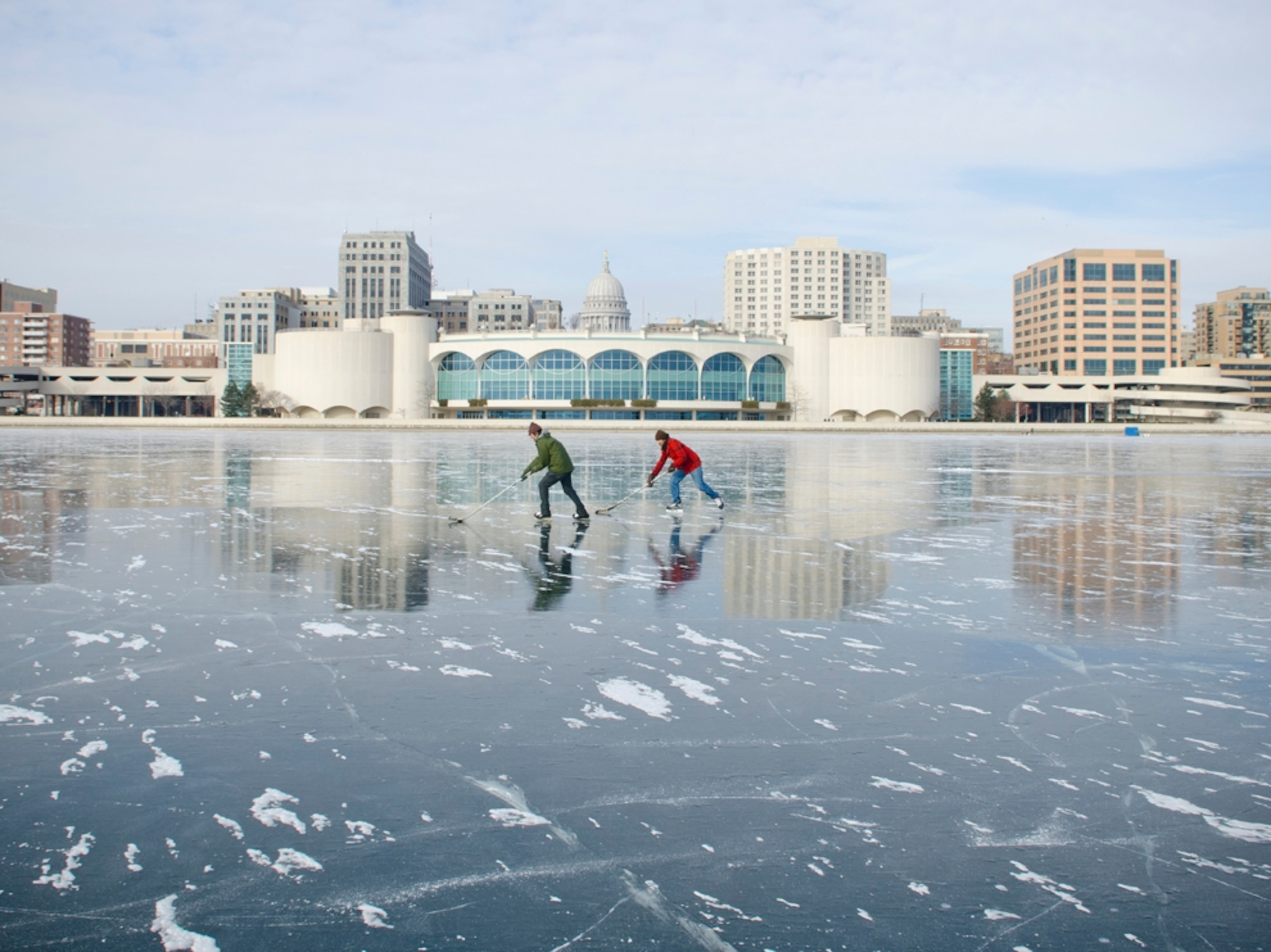 two men playing ice hockey on Lake Monona in Madison, Wisconsin.
