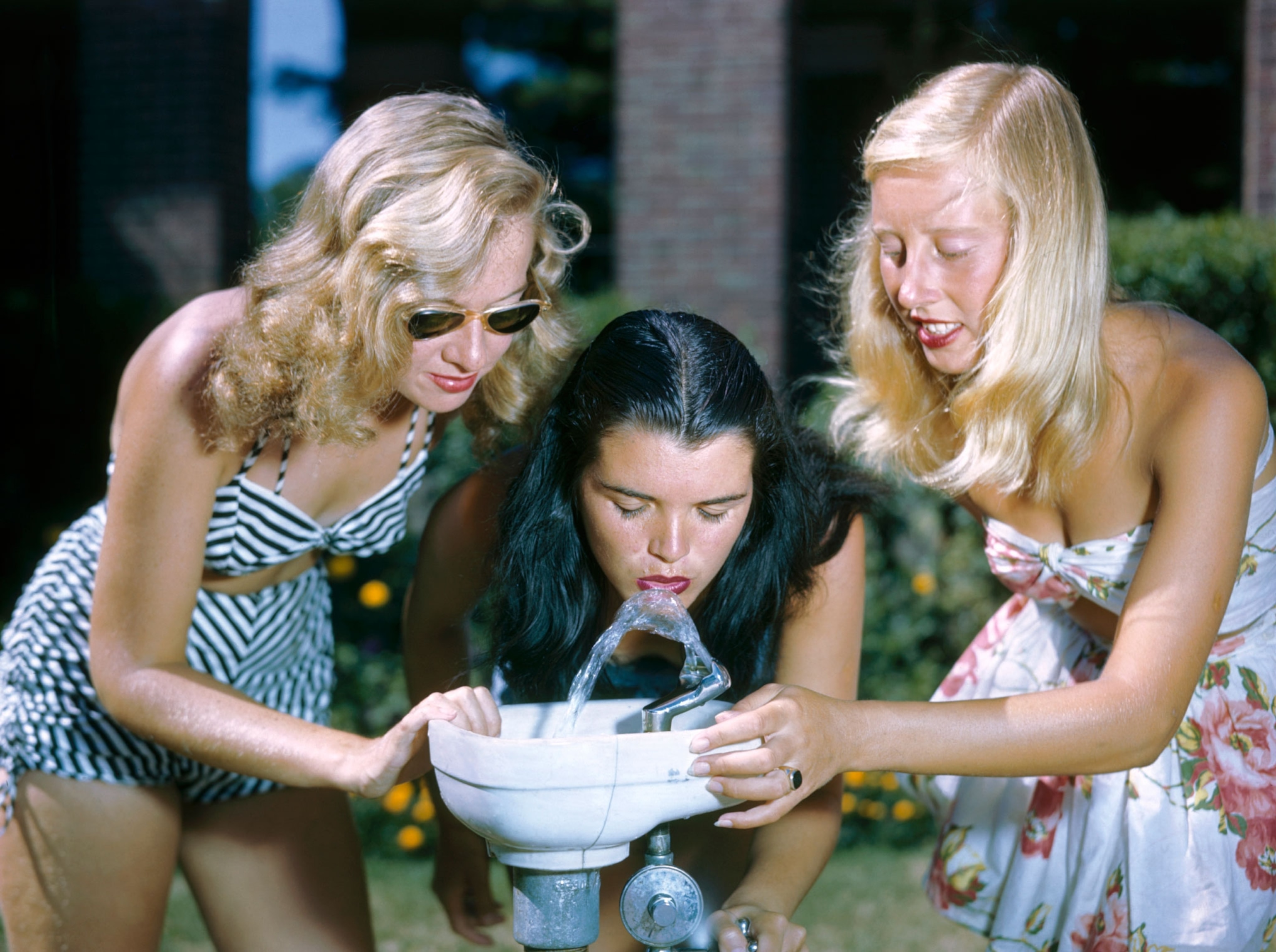 girls at water fountain with fashionable swimsuits