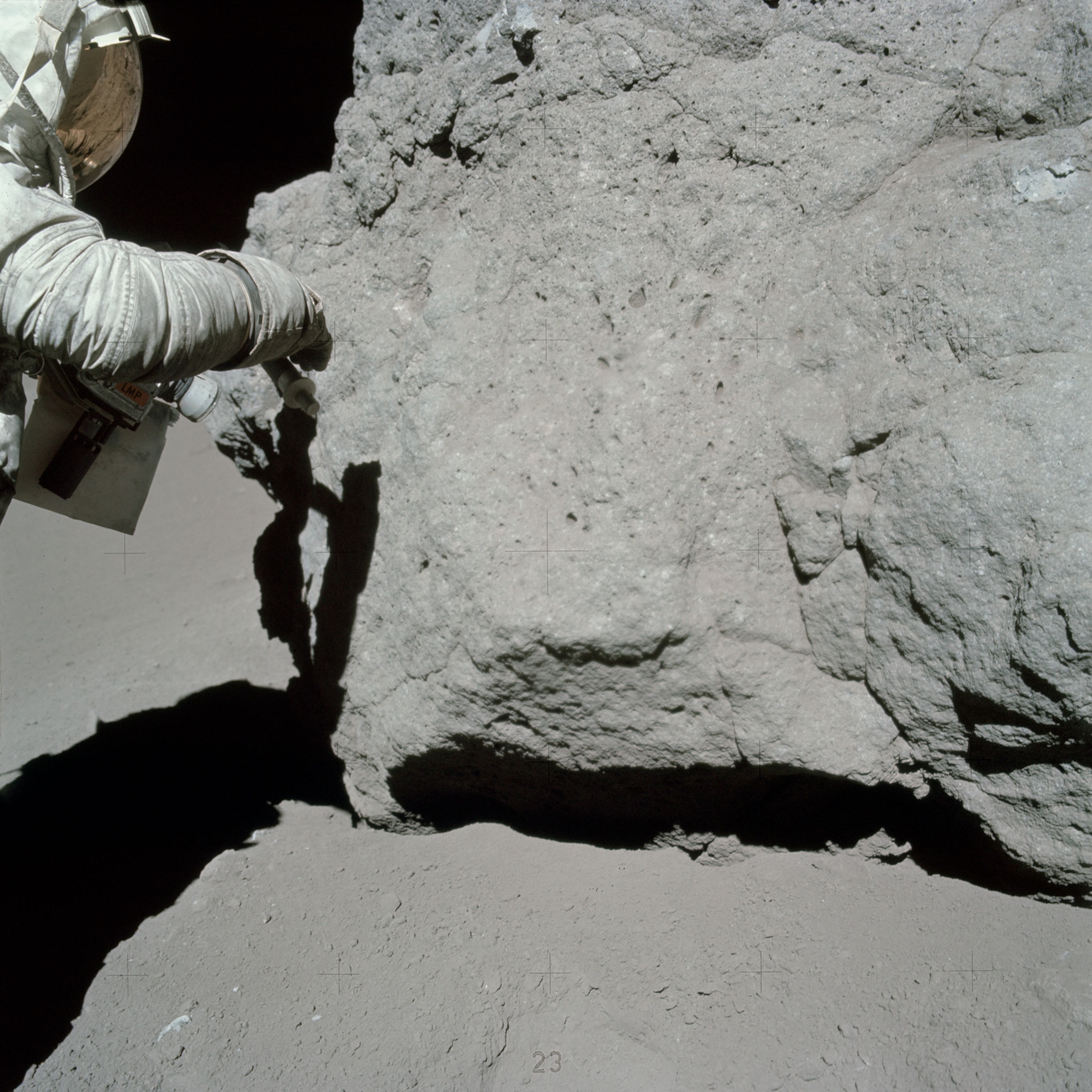 an astronaut taking a rock sample on the moon