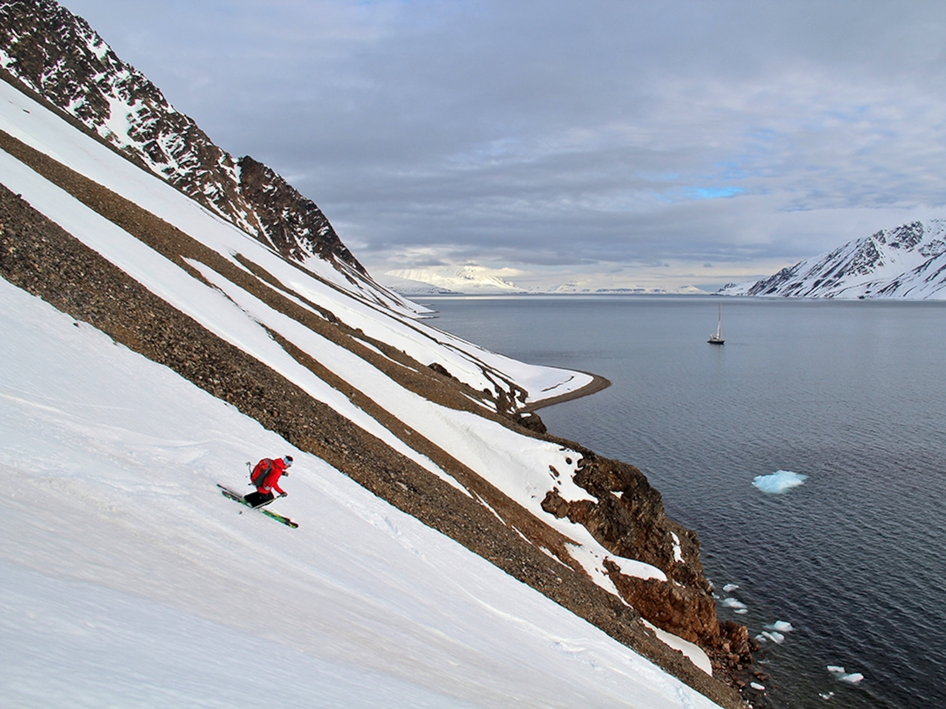 man skiing down a mountain in Svalbard, Norway