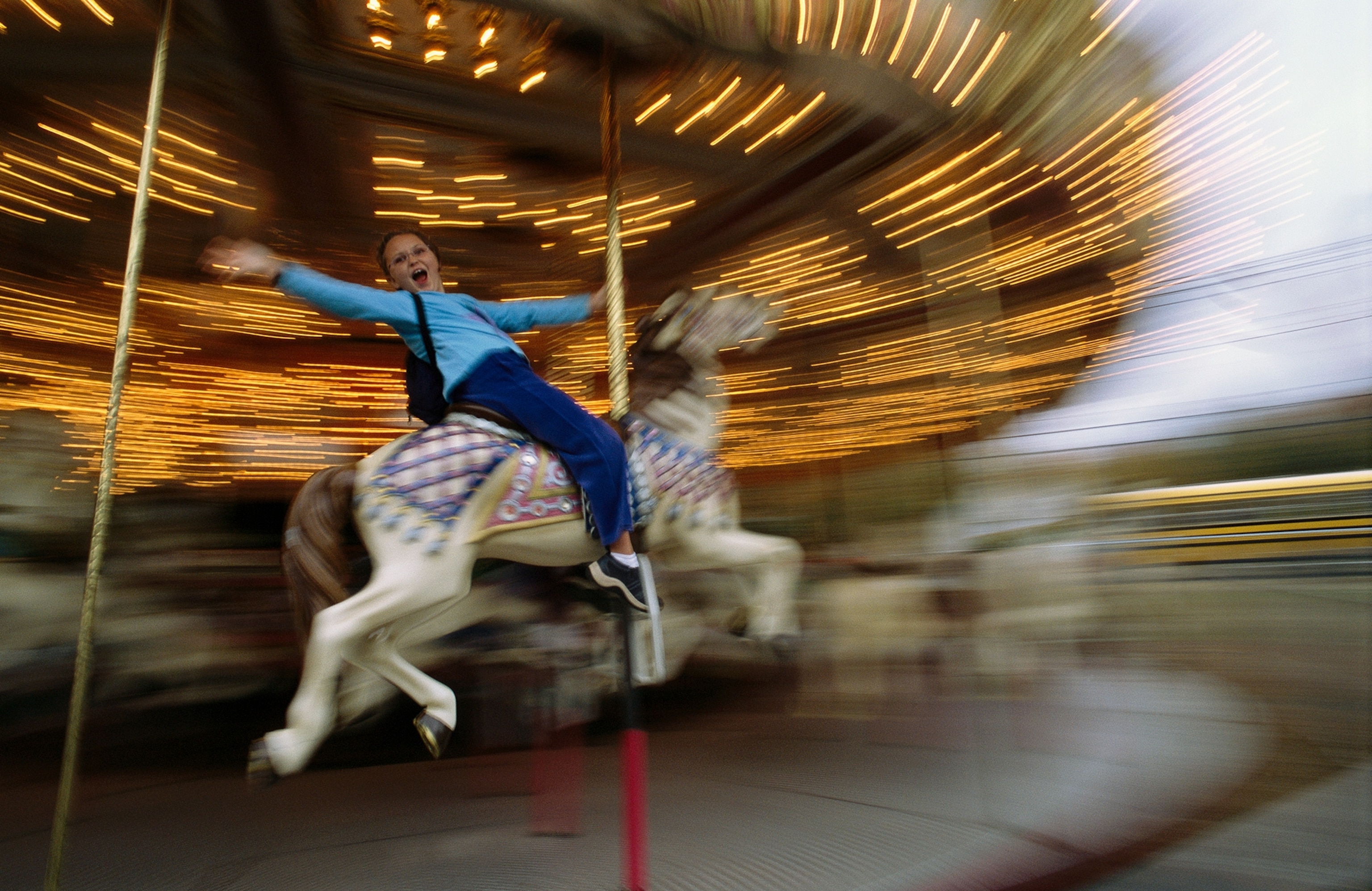 An American girl joyfully rides a carousel at a fair in New Hampshire