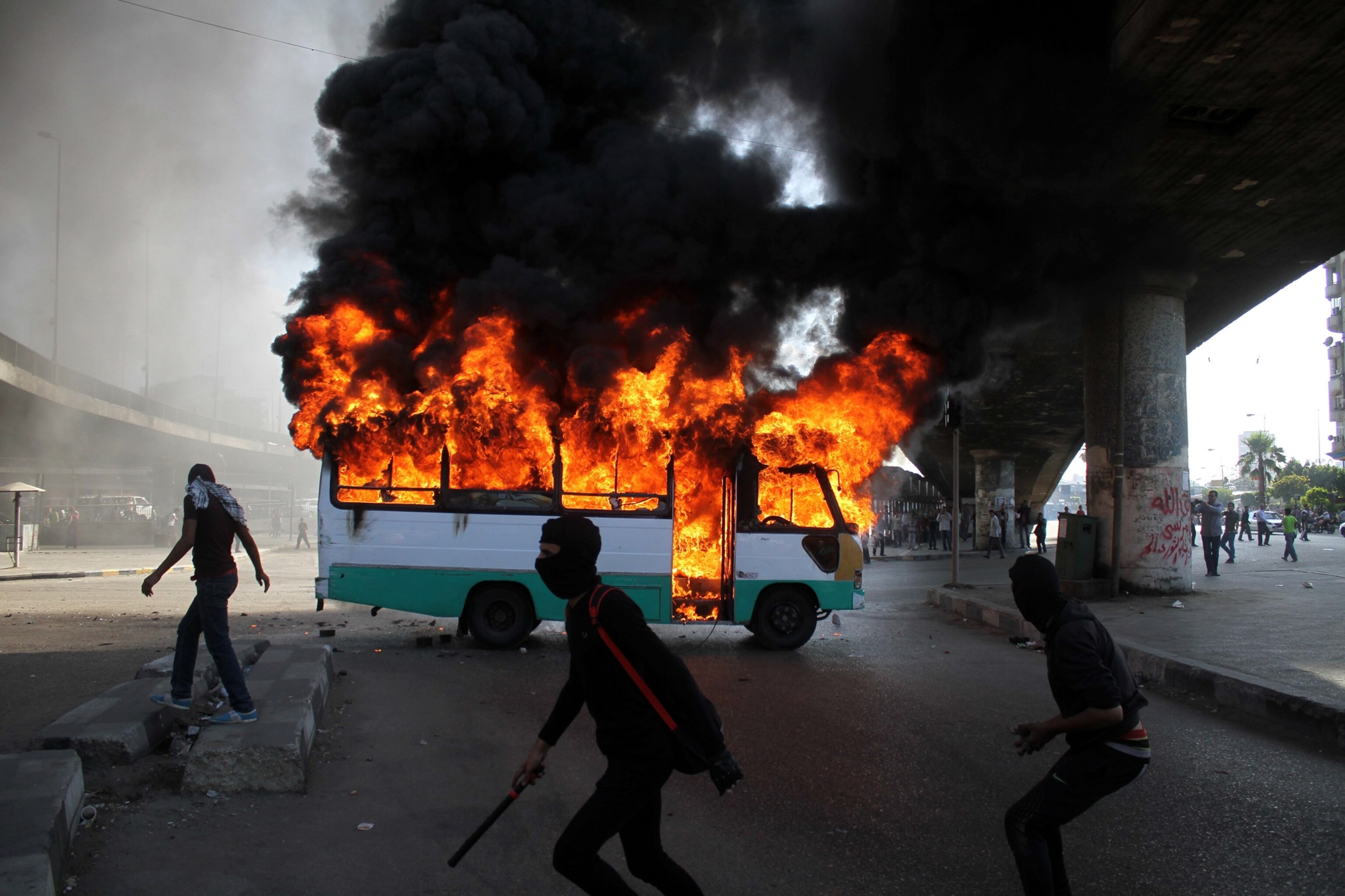 protesters near a burning bus in Cairo, Egypt