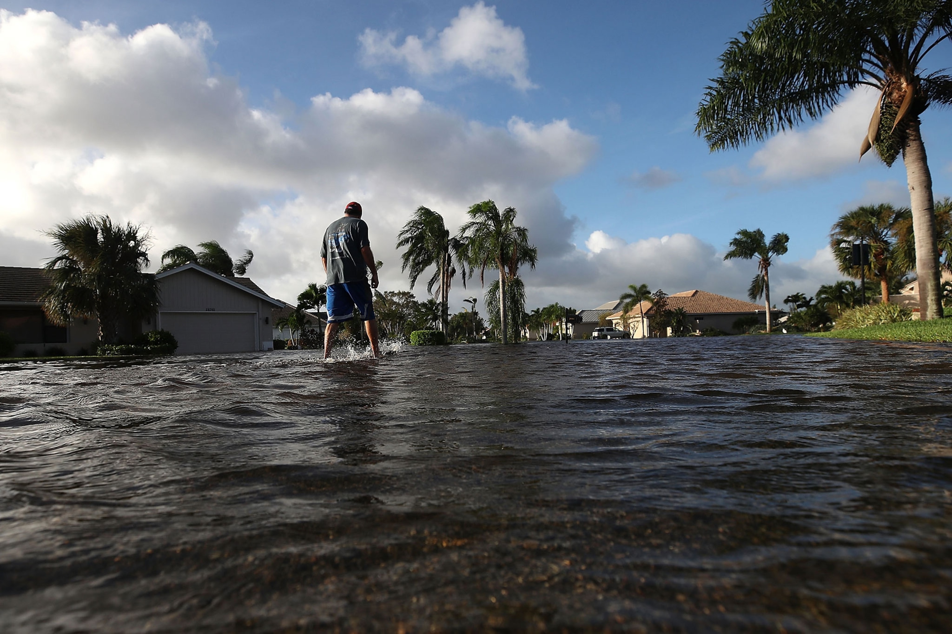 a man walks through Hurricane Irma floodwaters in Bonita Springs, Florida