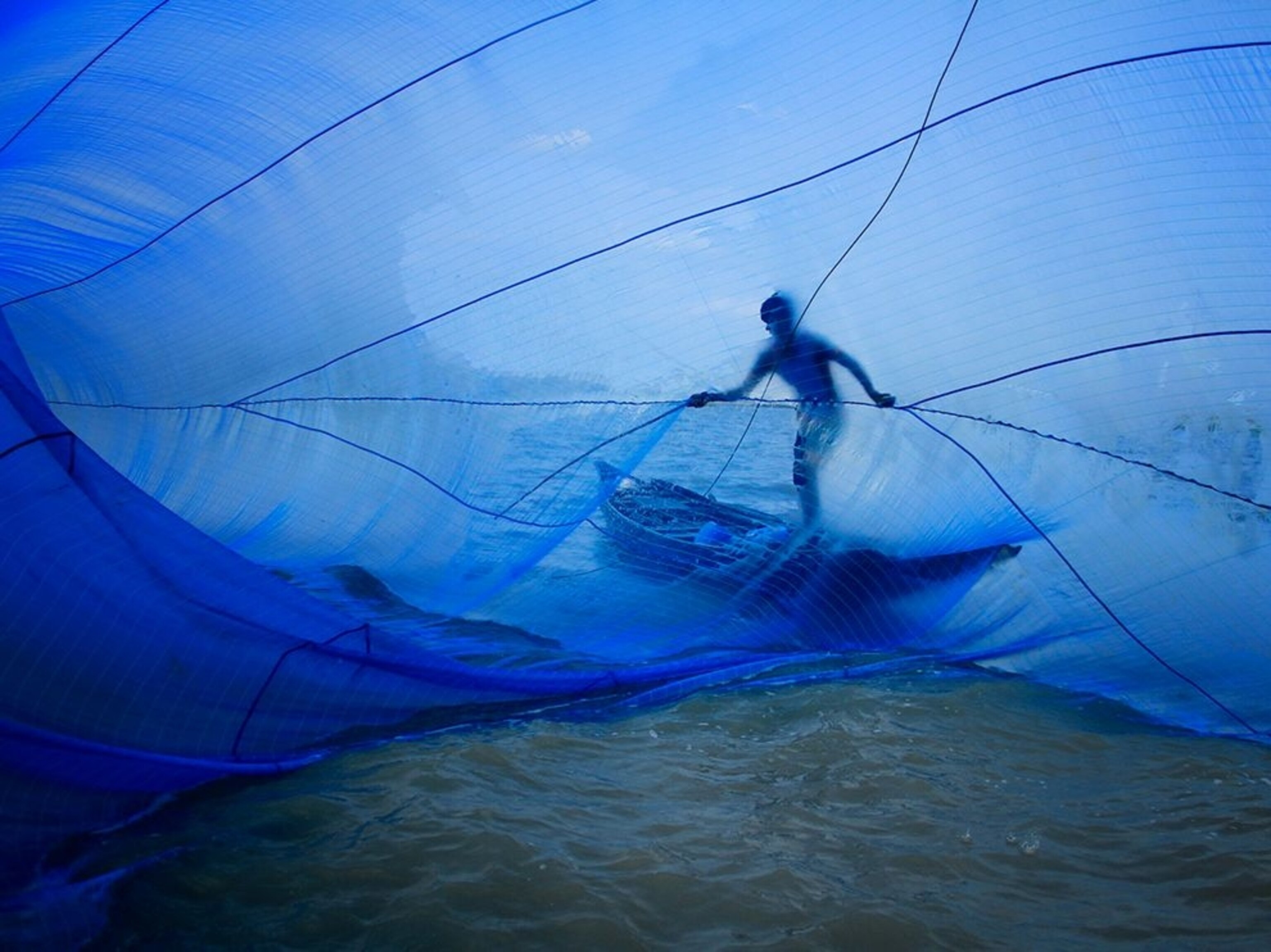 a fisherman with a blue net in Bangladesh, India