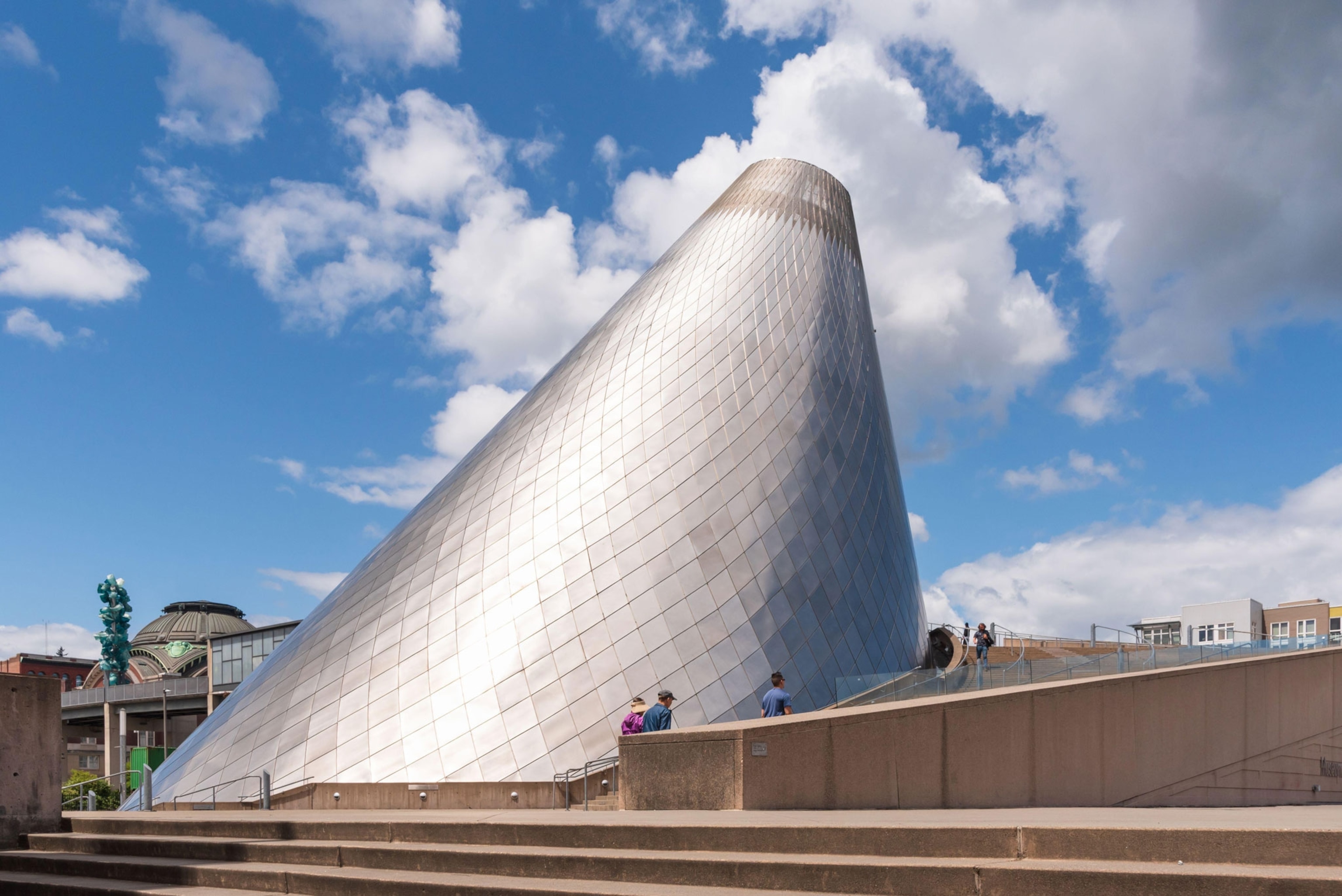 A distinct building featuring an easily recognized truncated of cone structure clad in stainless steel.