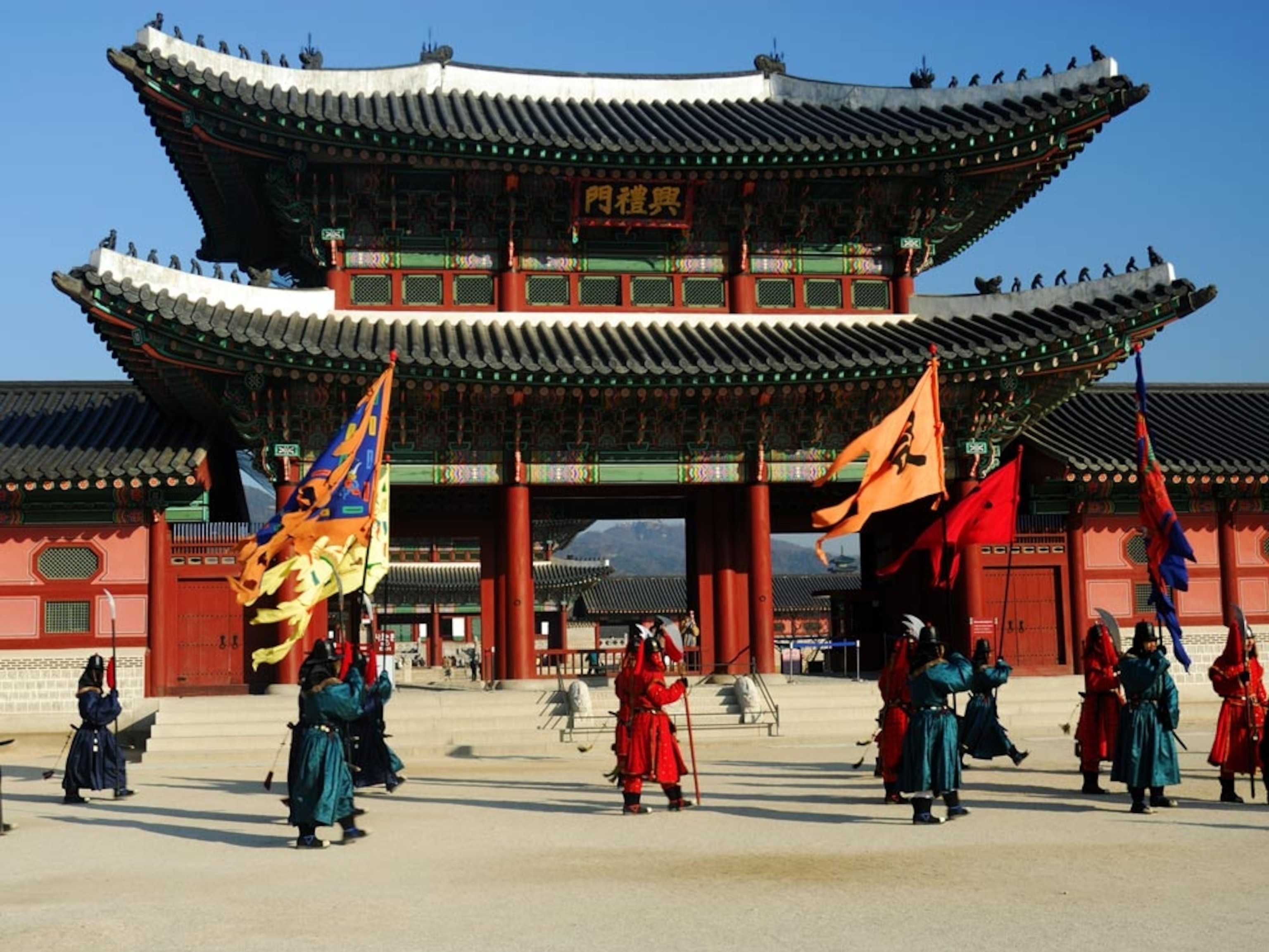 Robed guards parading before a pagoda