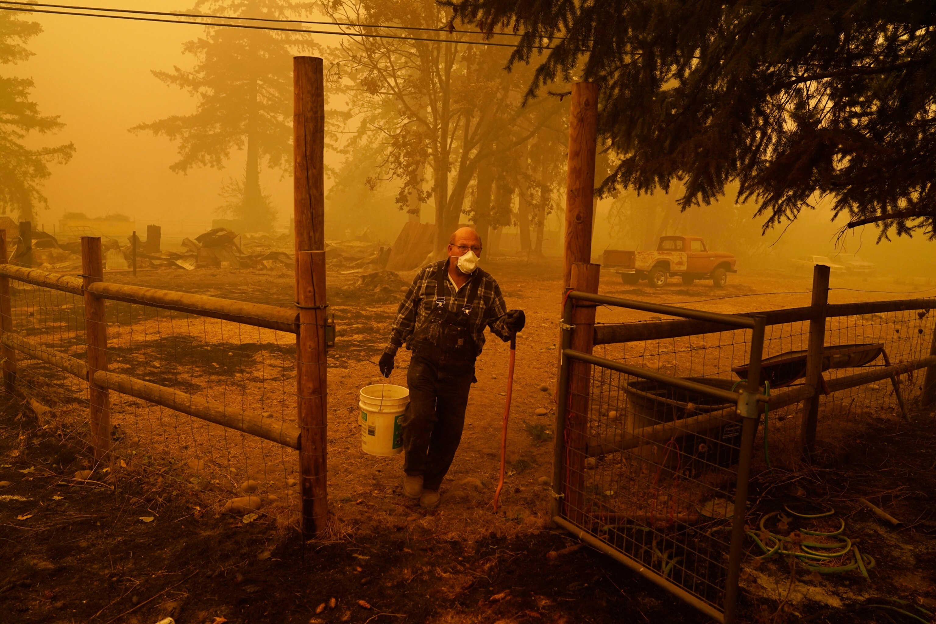 George Coble carries a bucket of water to put out a smoldering tree