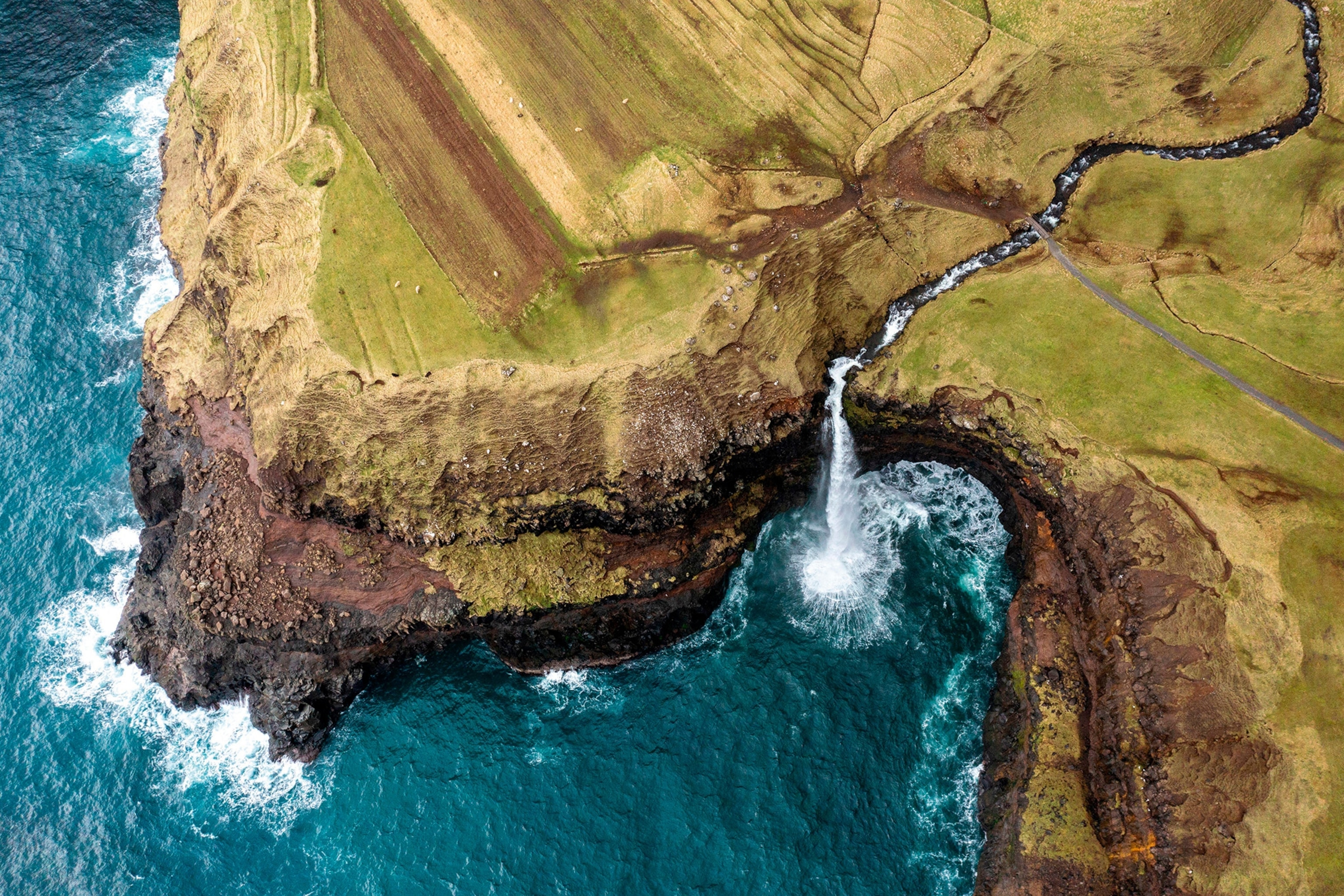 An aerial shot of Múlafossur waterfall in Gásadalur