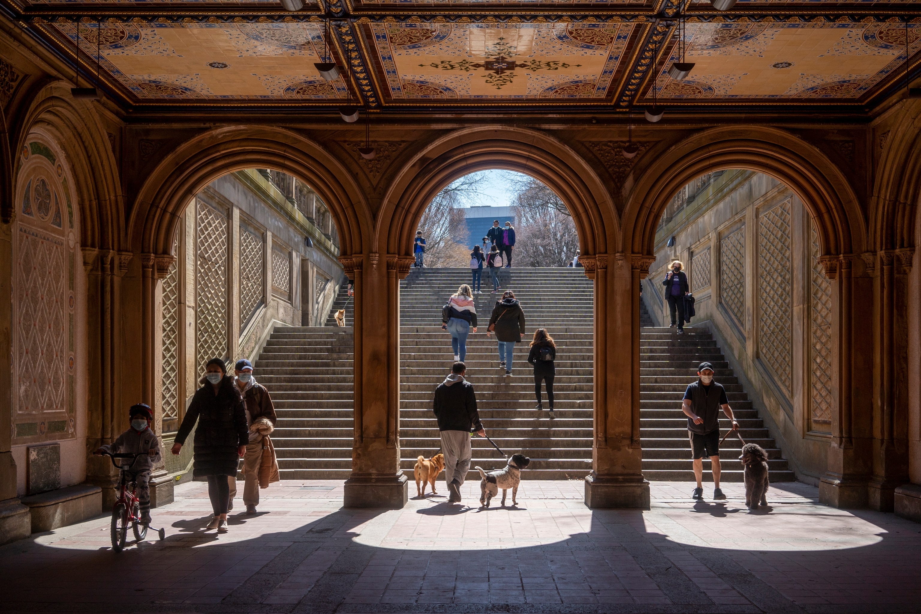 People walk through three archways beneath Central Park in New York