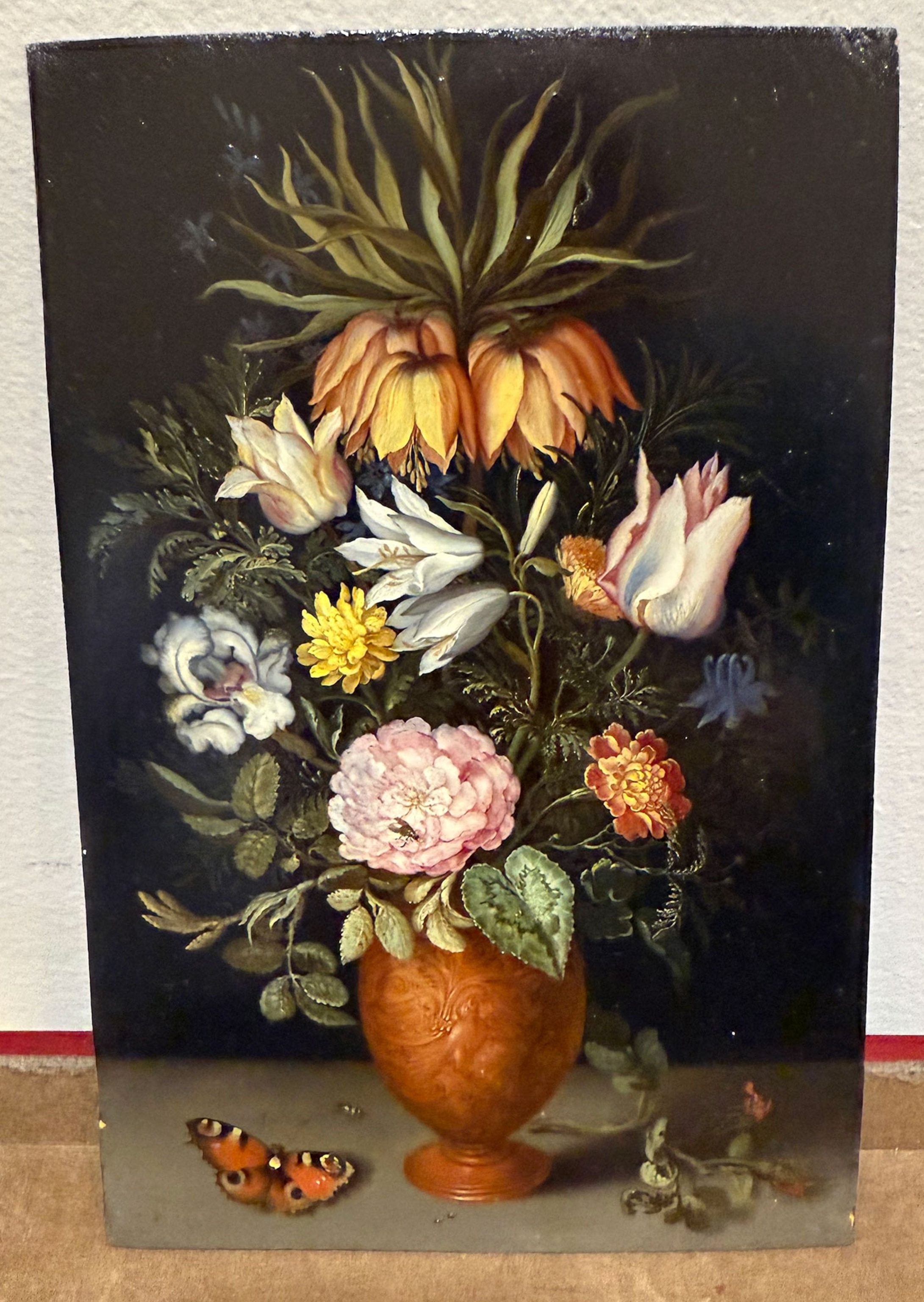 A painting of flowers photographed while leaning against a wall.