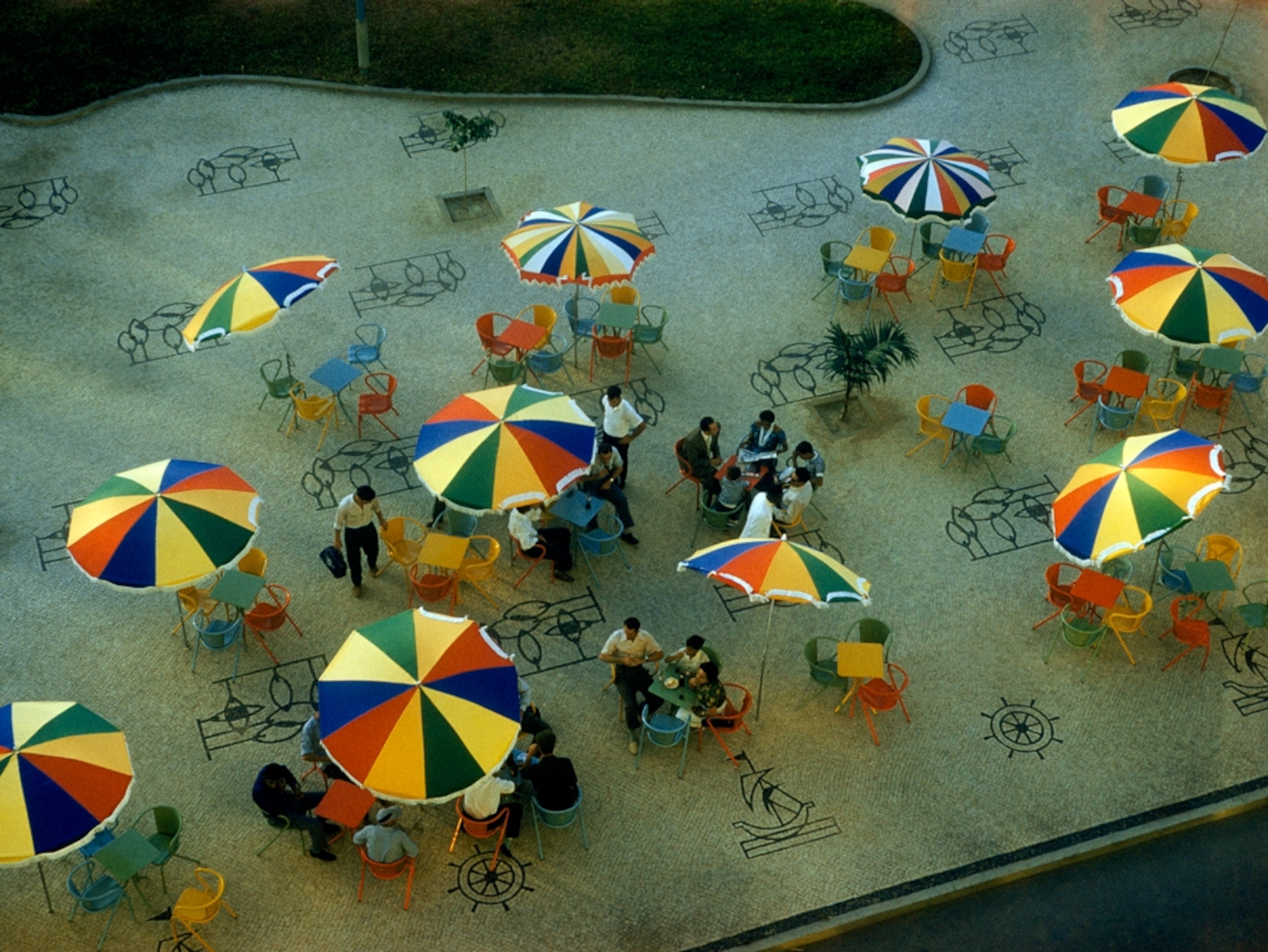 Mosaics and umbrellas on a sidewalk seen from above