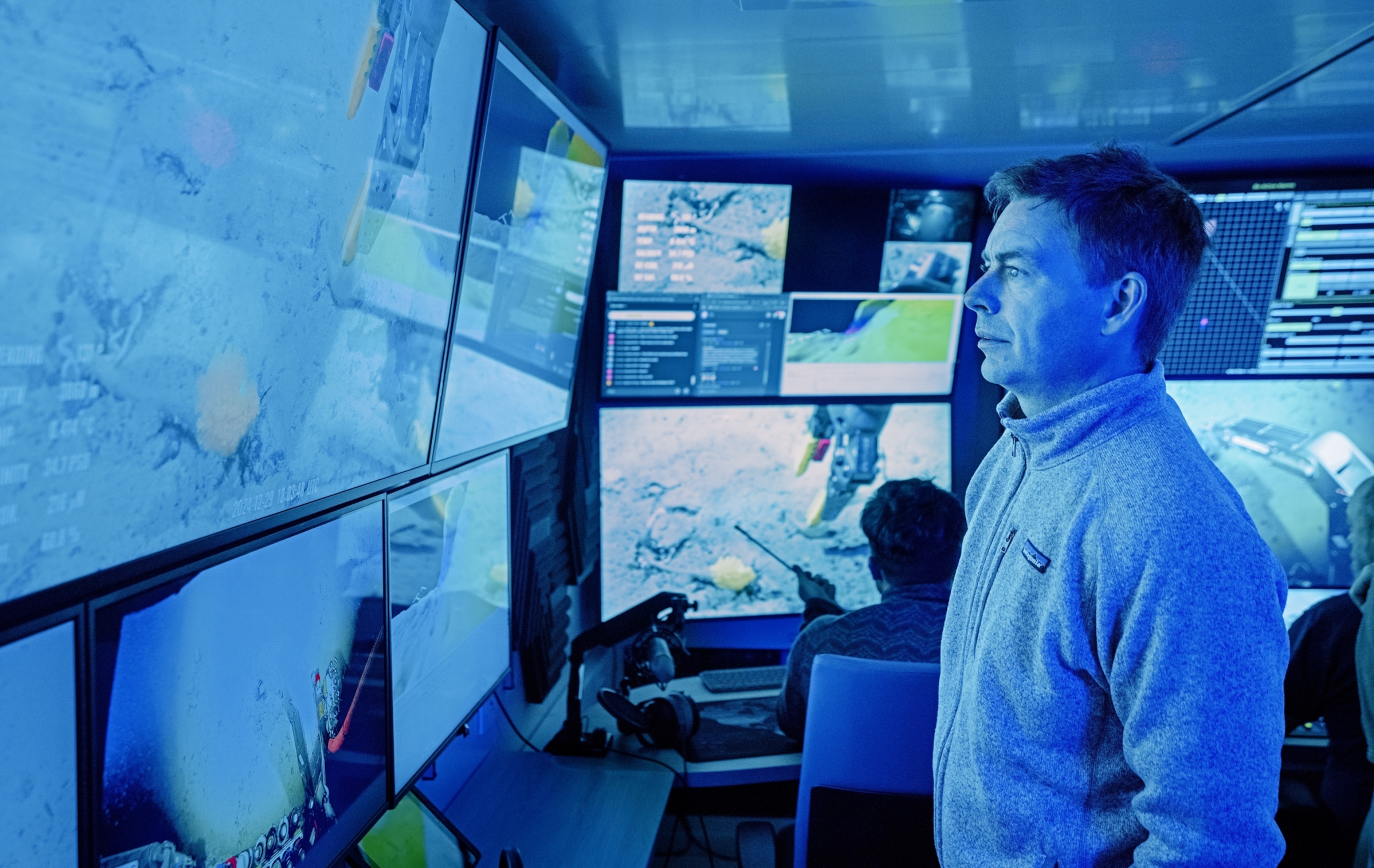 Man in blue light from monitors he is looking at.