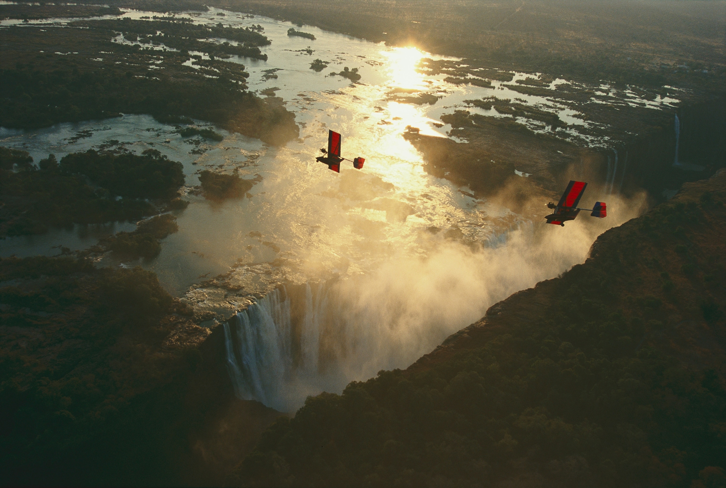 Ultralights fly over mile-wide Victoria Falls on the Zambezi River.