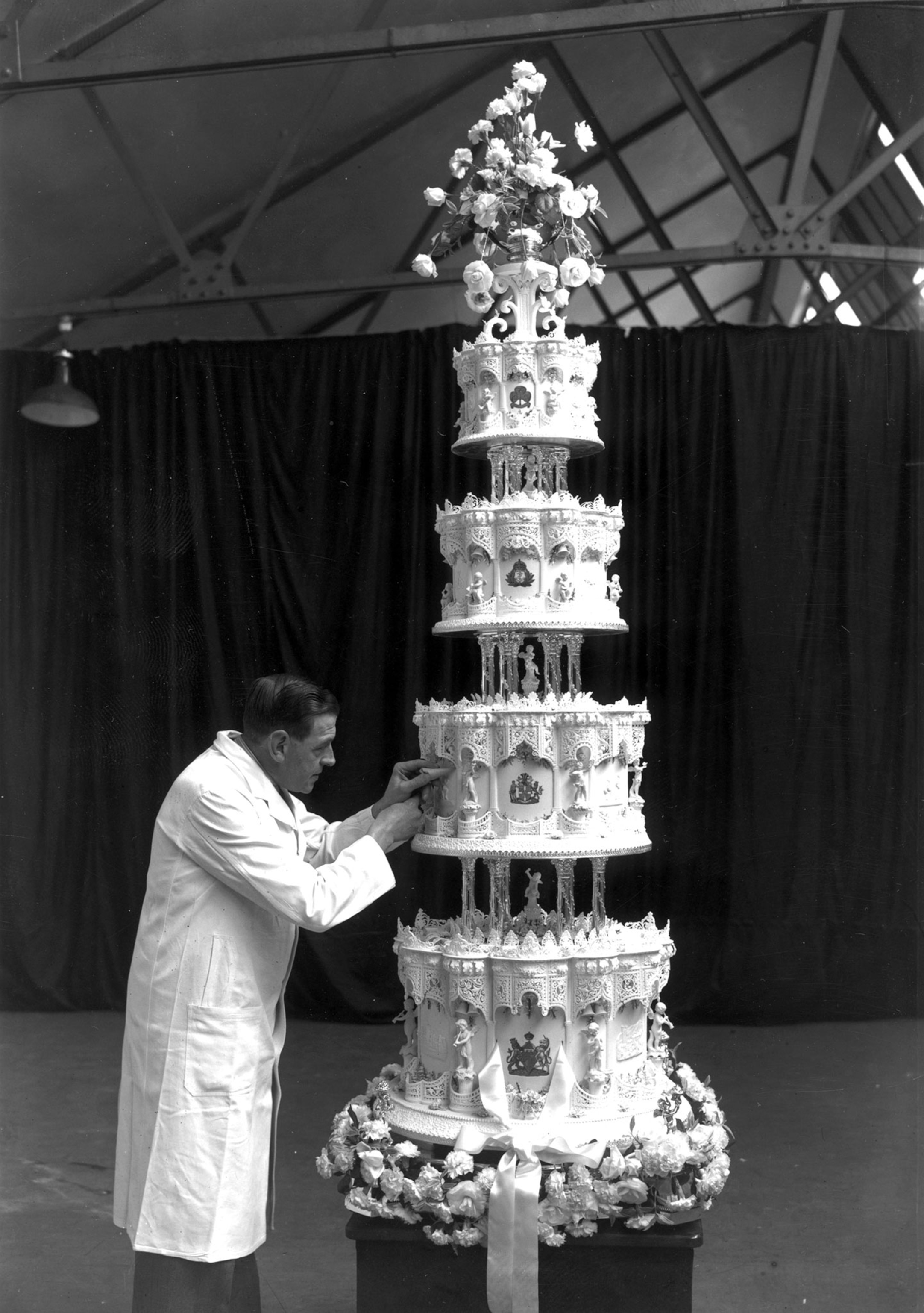 a confectioner putting the final touches to the wedding cake of Princess Elizabeth