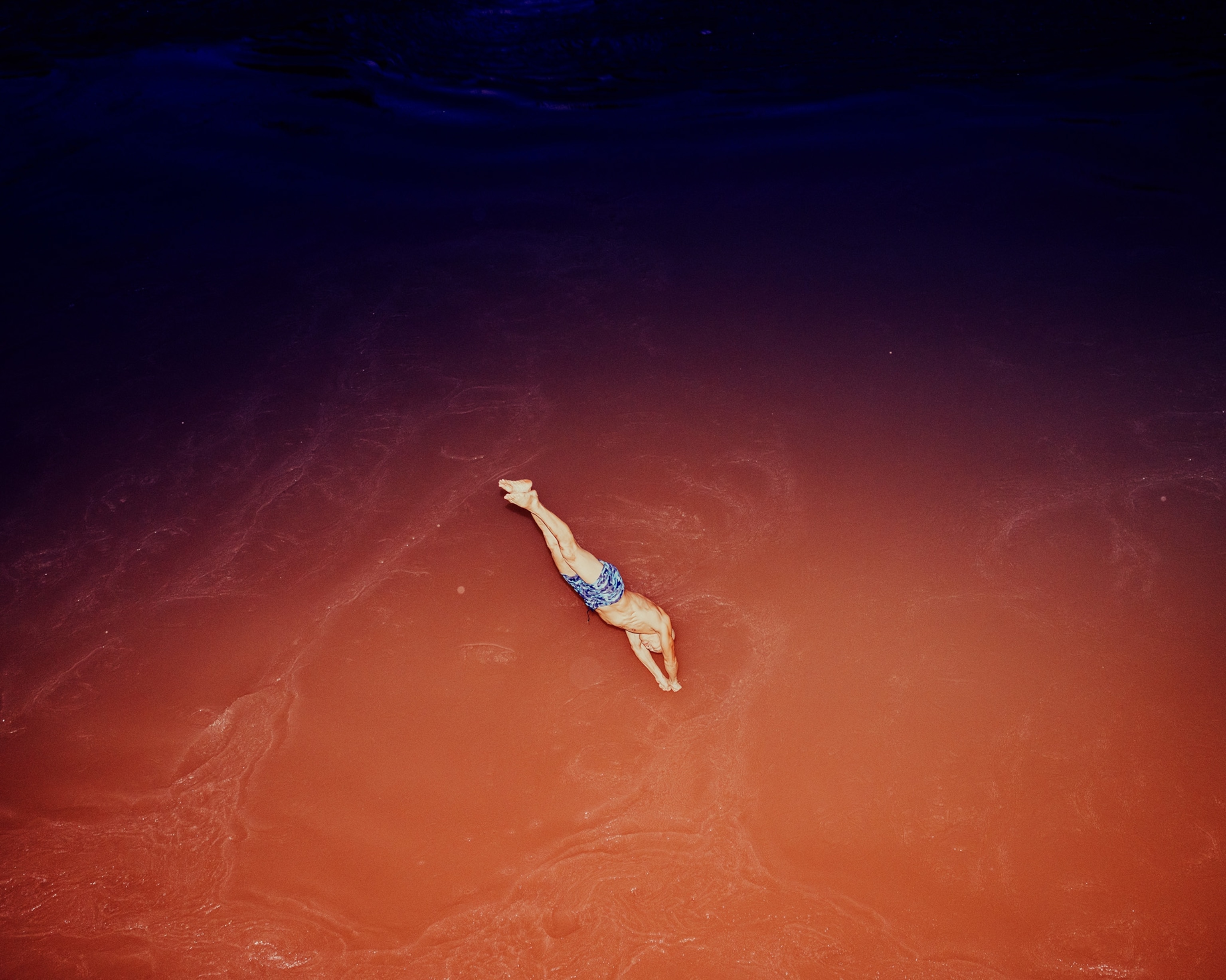 A man plunges into the brown-colored Jialing River in Chongqing, China.