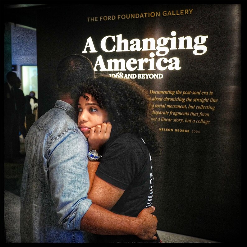 A young man comforts his friend after taking a tour at the new African American Museum of History and Culture in Washington, D.C., during the opening weekend of the museum.