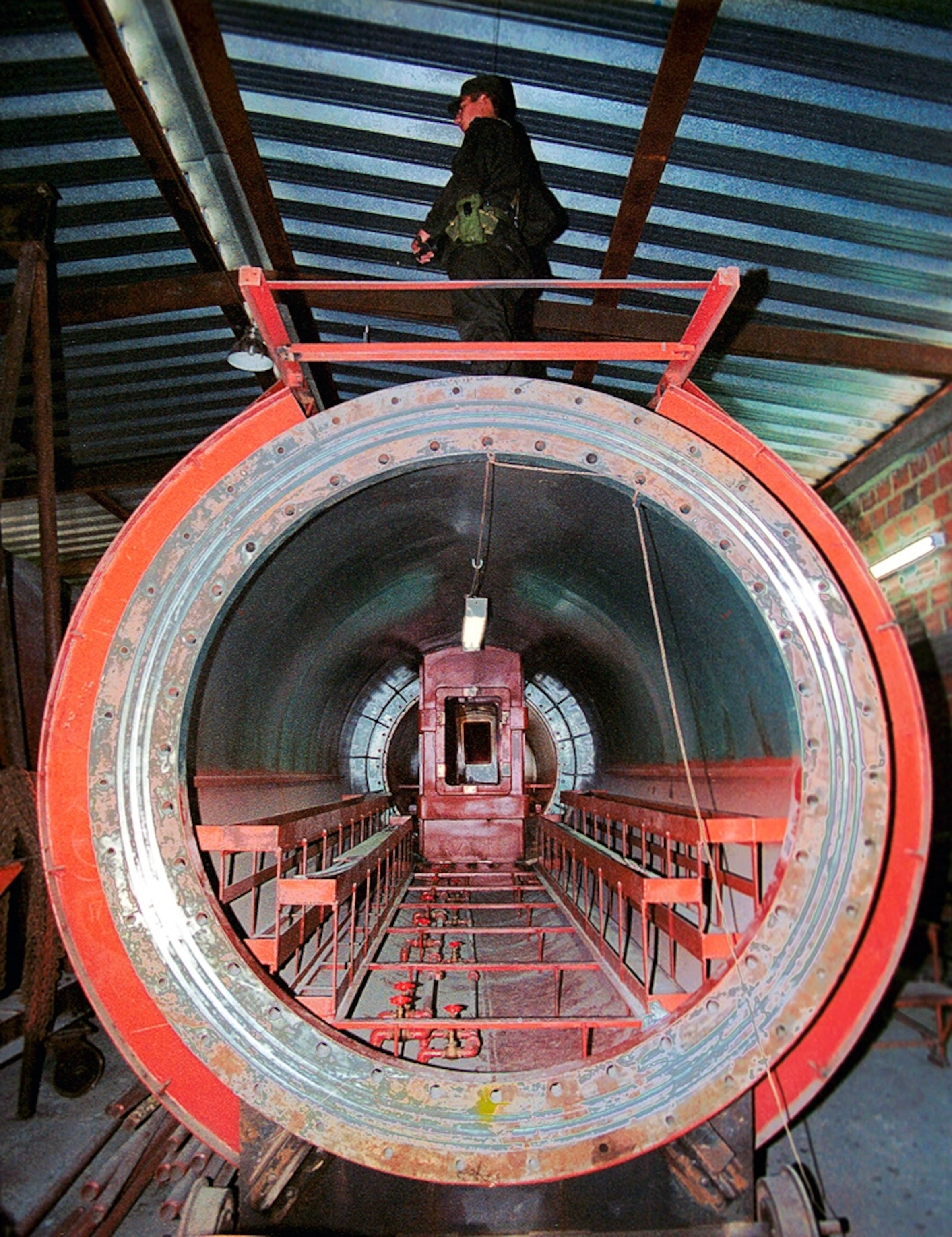 Picture of a police officer standing atop an under-construction cocaine submarine