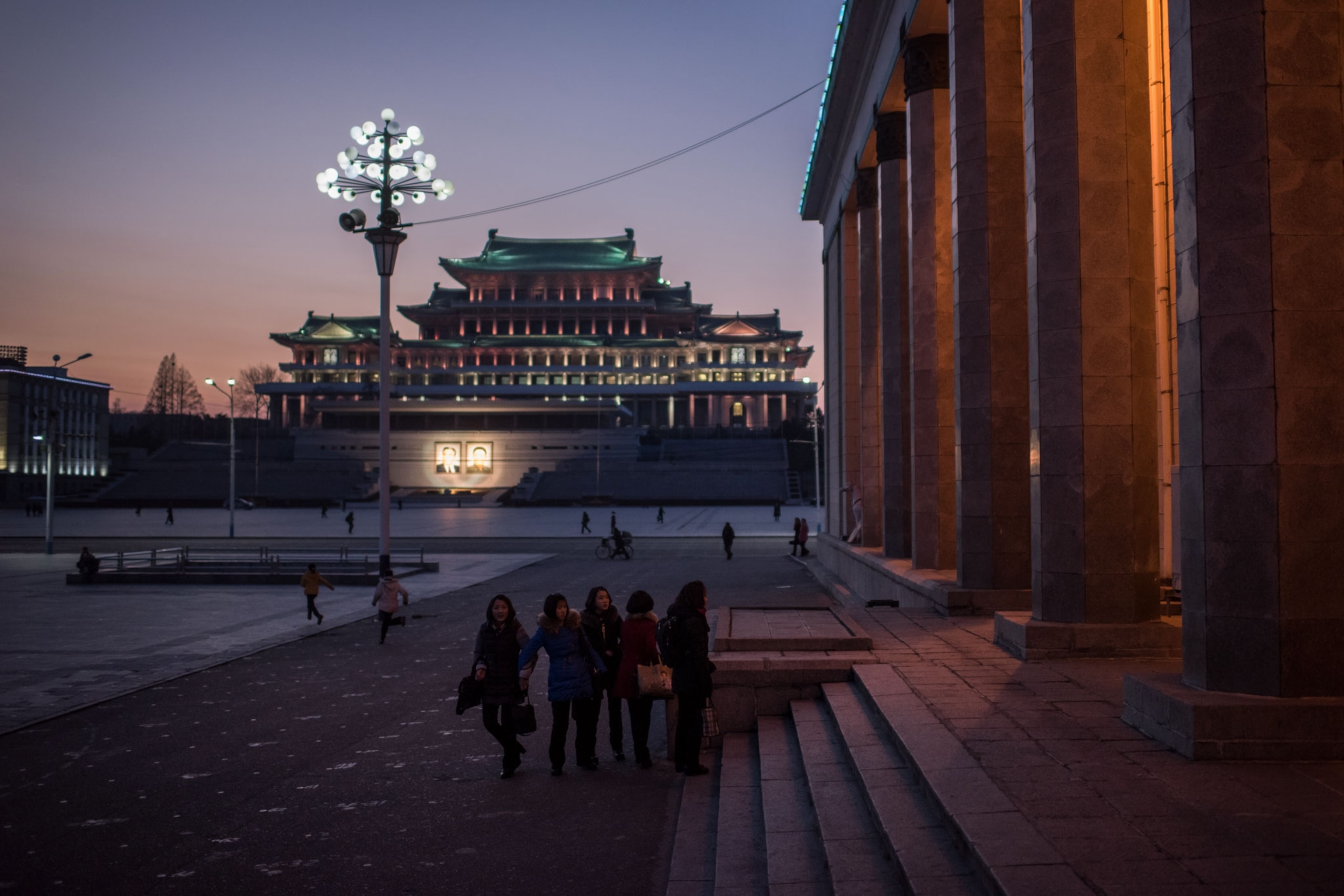 people walking at dusk in North Korea