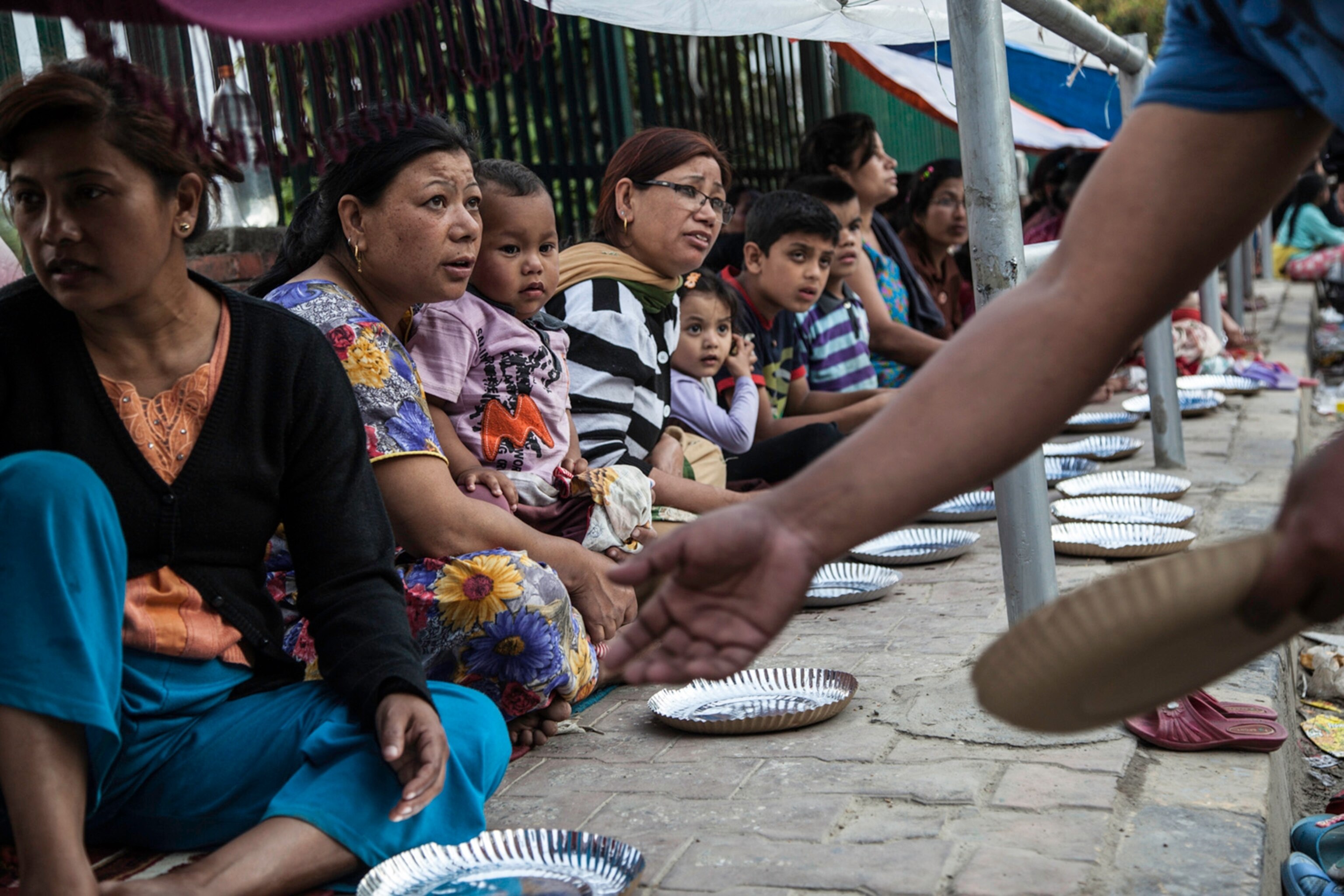 Nepalese people affected by the recent earthquake wait to receive food in Kathmandu