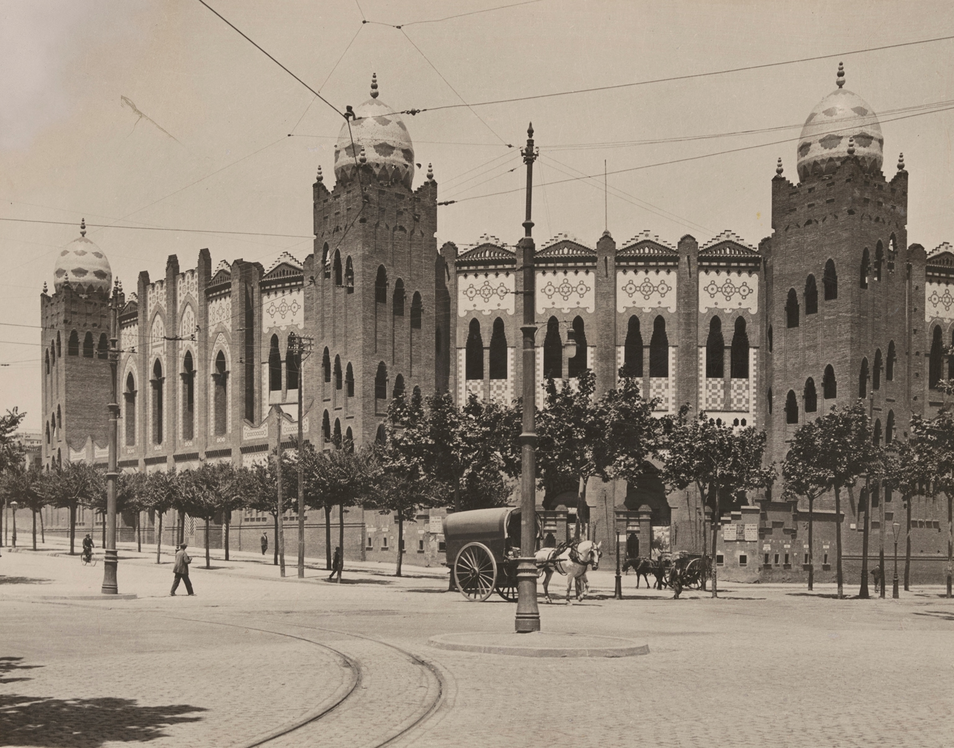 Distant people walk on the street outside a bull ring in Barcelona.
