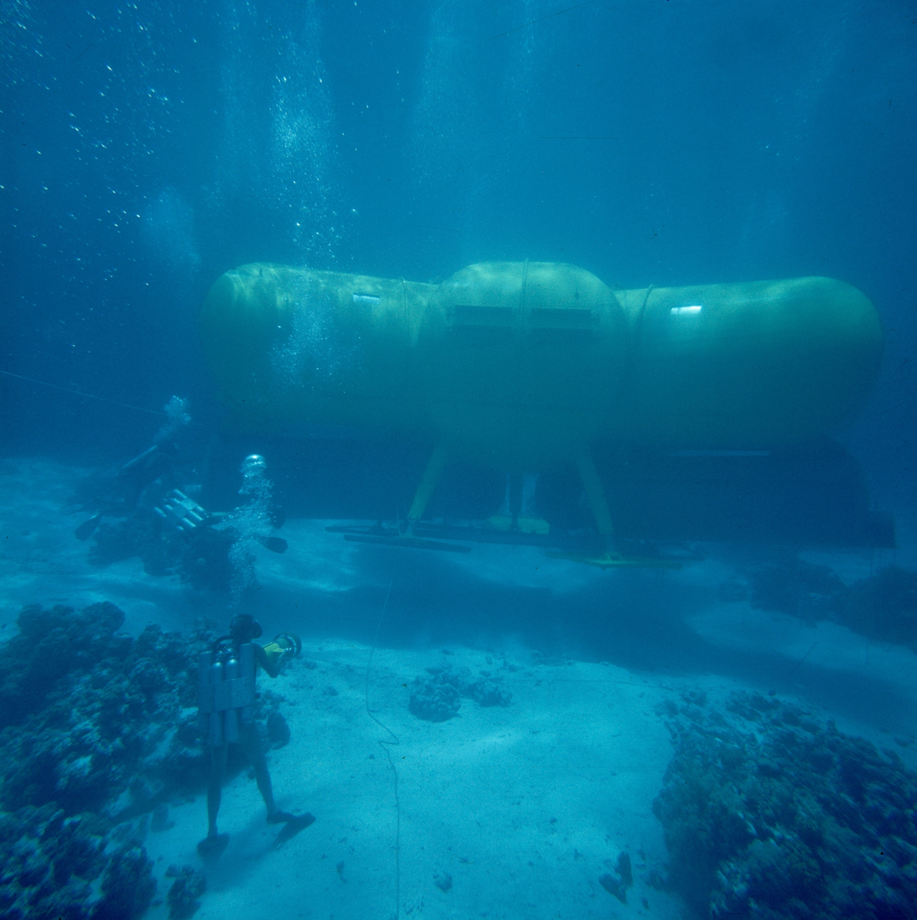 A diver films as a submersible is lowered to the sea floor.