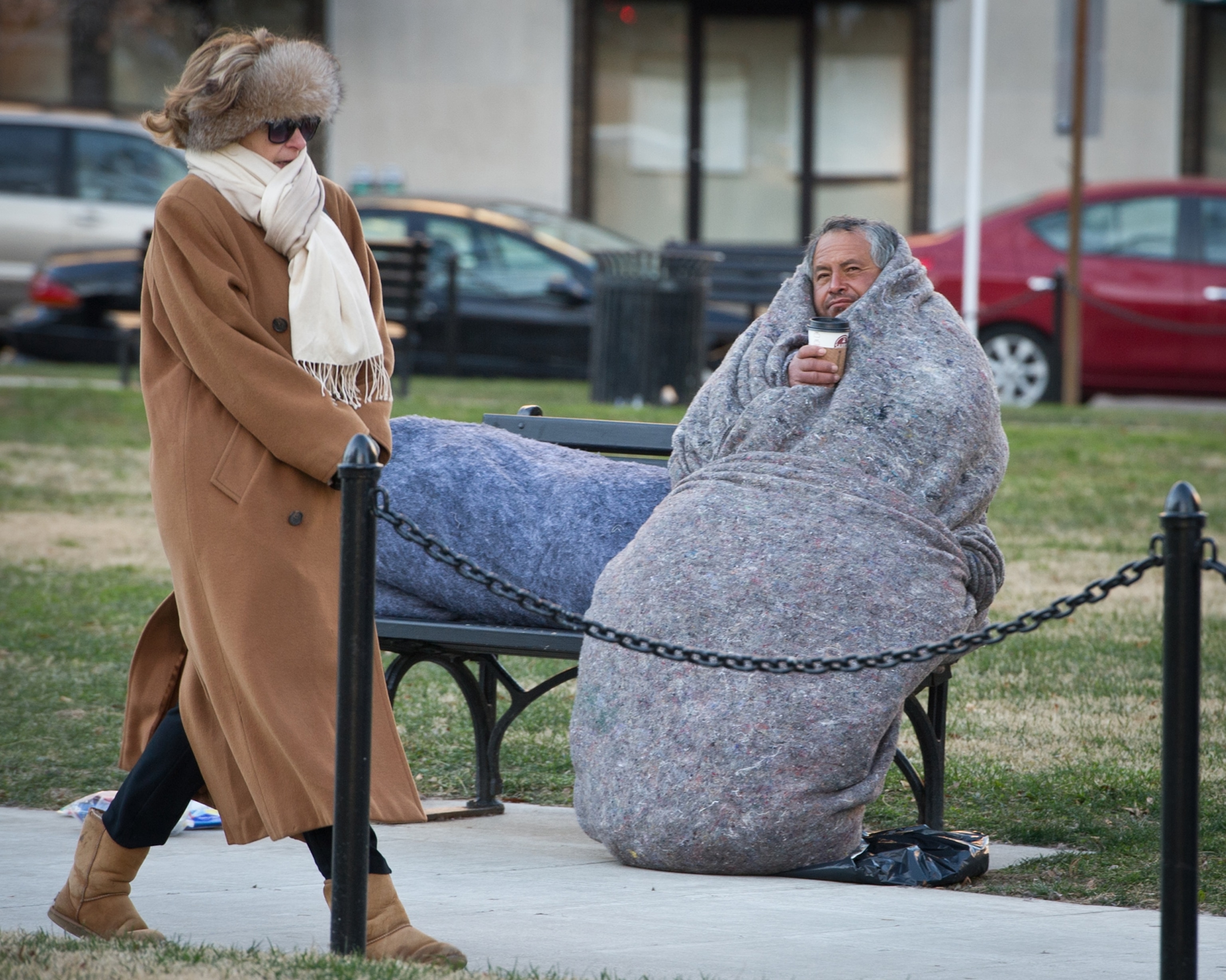 a pedestrian and a homeless man in McPherson Square in Washington, D.C.