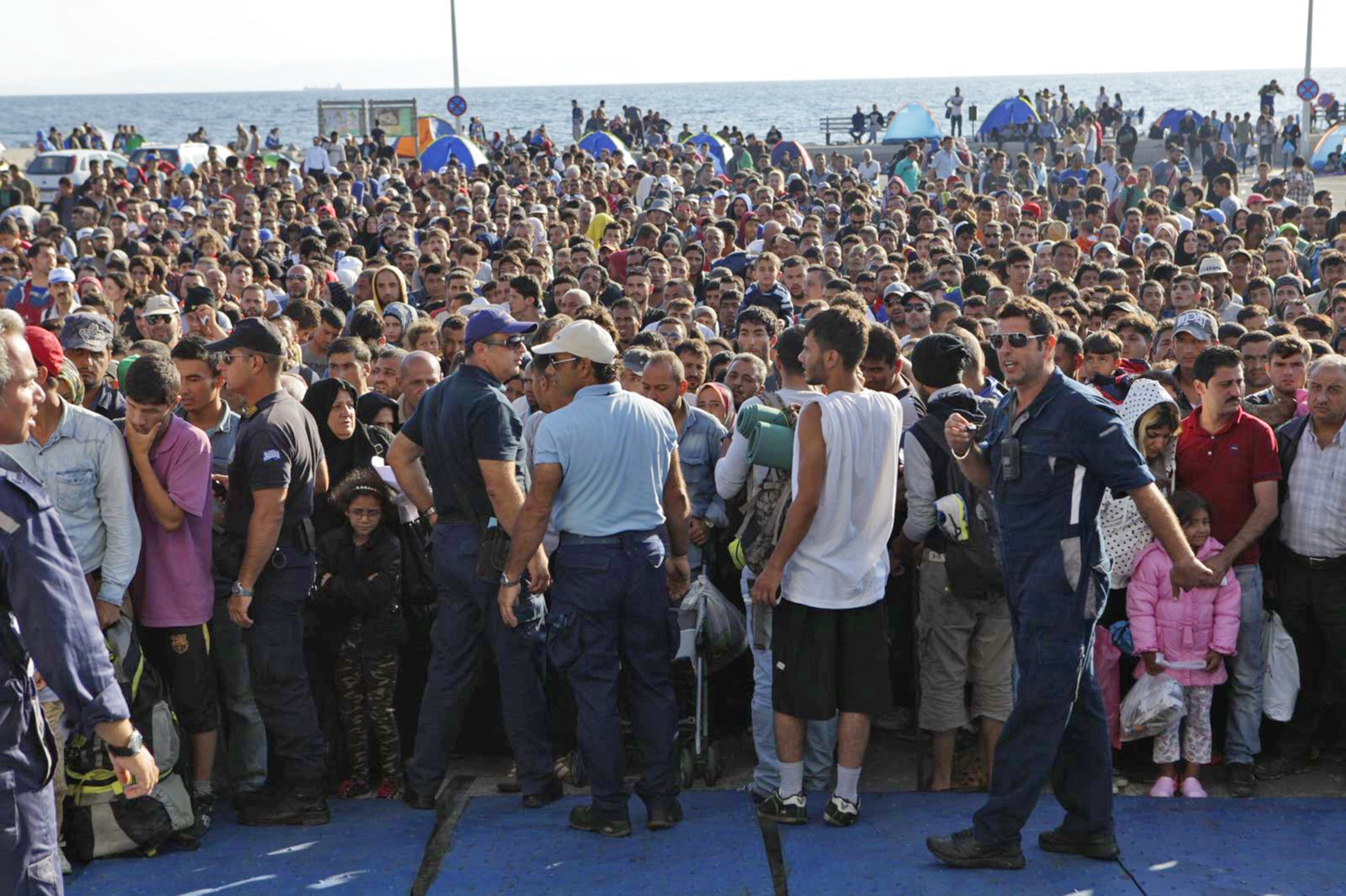 Refugees waiting to get on a ferry at the port in Mitilini