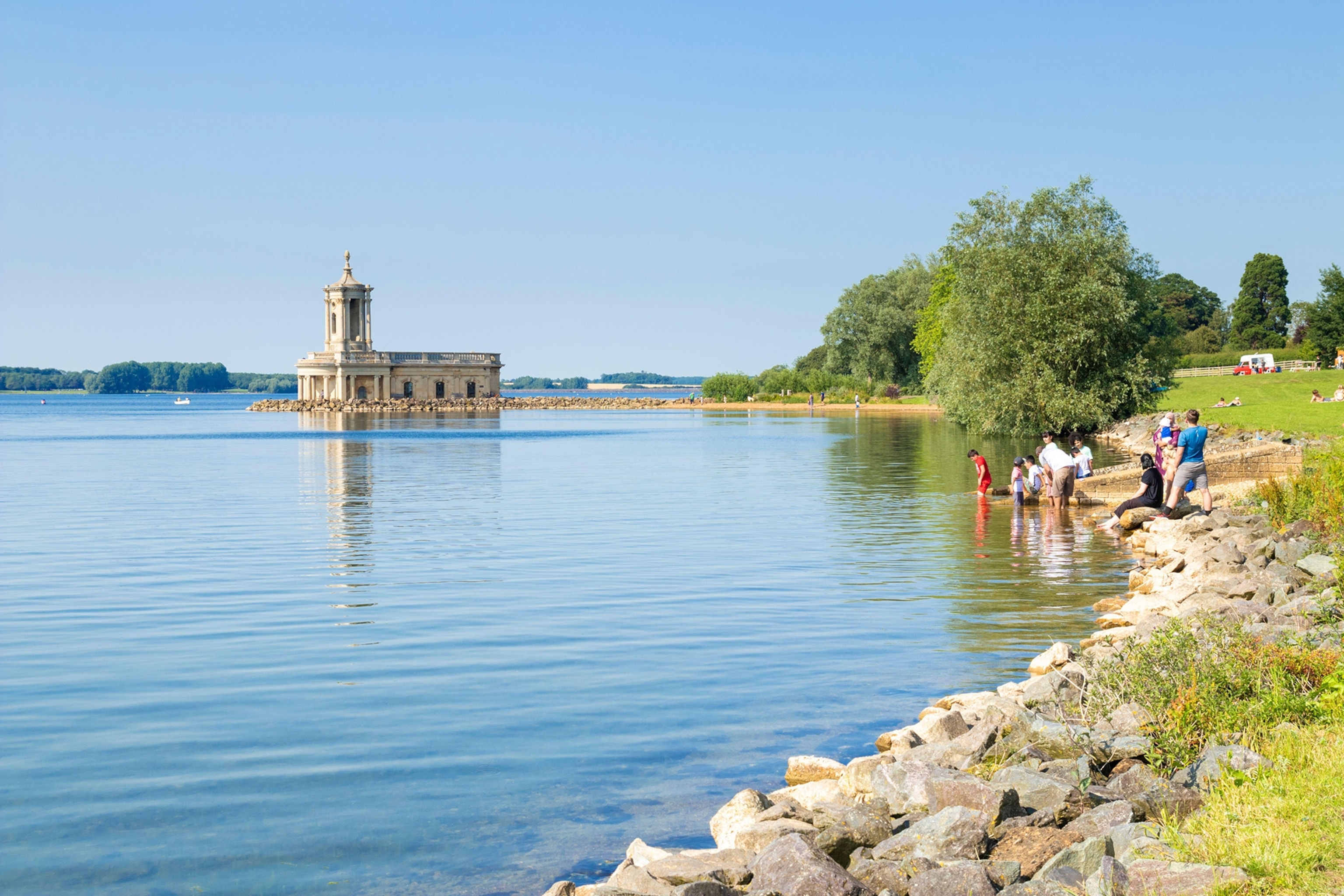 wide body of water, people paddling in the distance