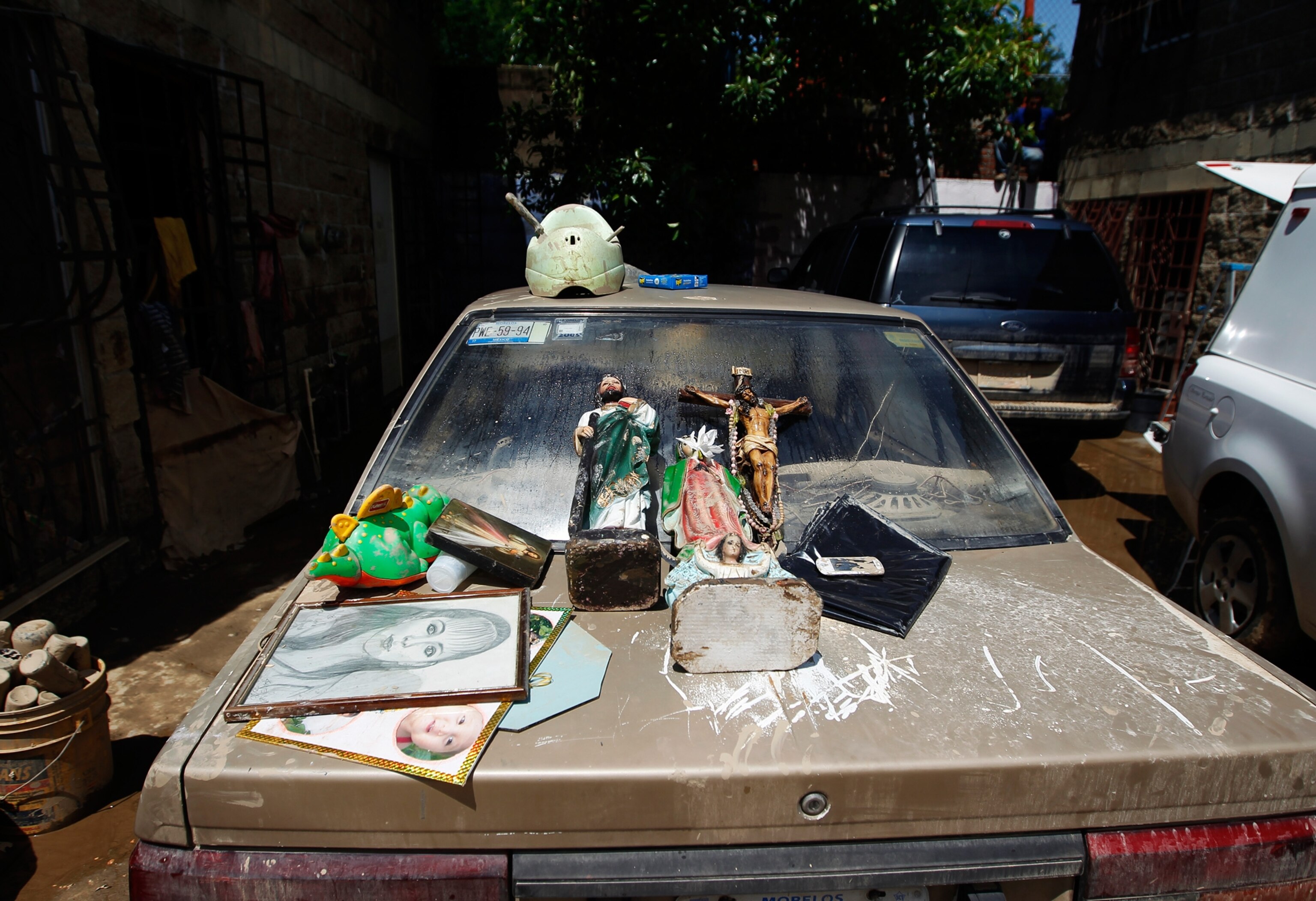 Pictures and religious figurines laid out on a car to dry in the flooded city of Acapulco, Mexico