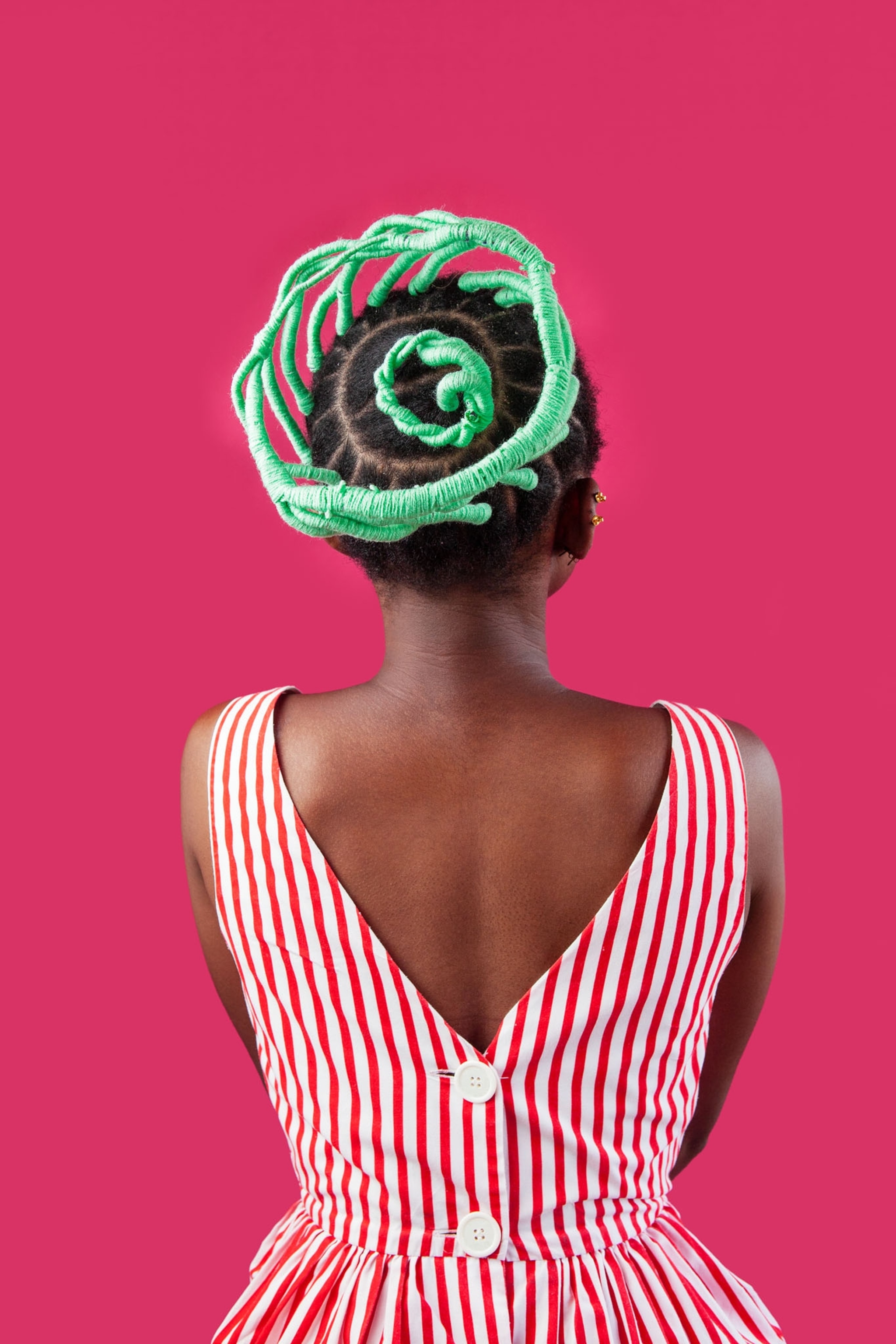 Picture of woman in pink strips on white dress with mint-green thread added to her hairdo.