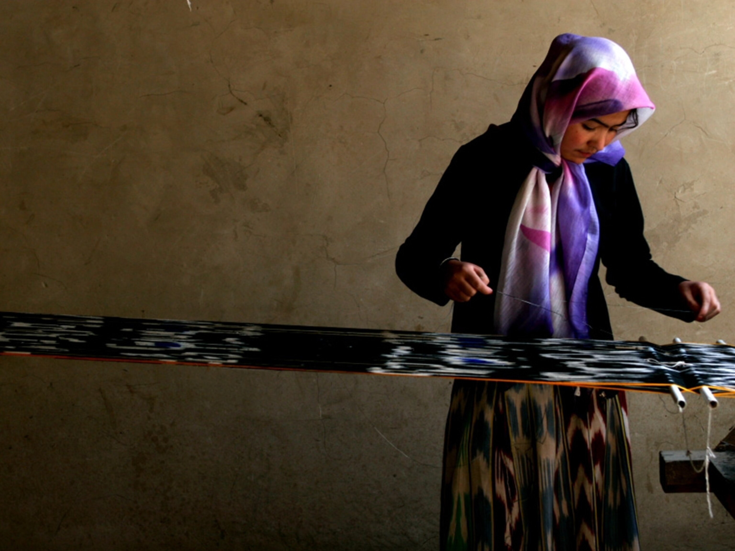 Girl weaves silk fabric, Hotan, Xinjiang, China