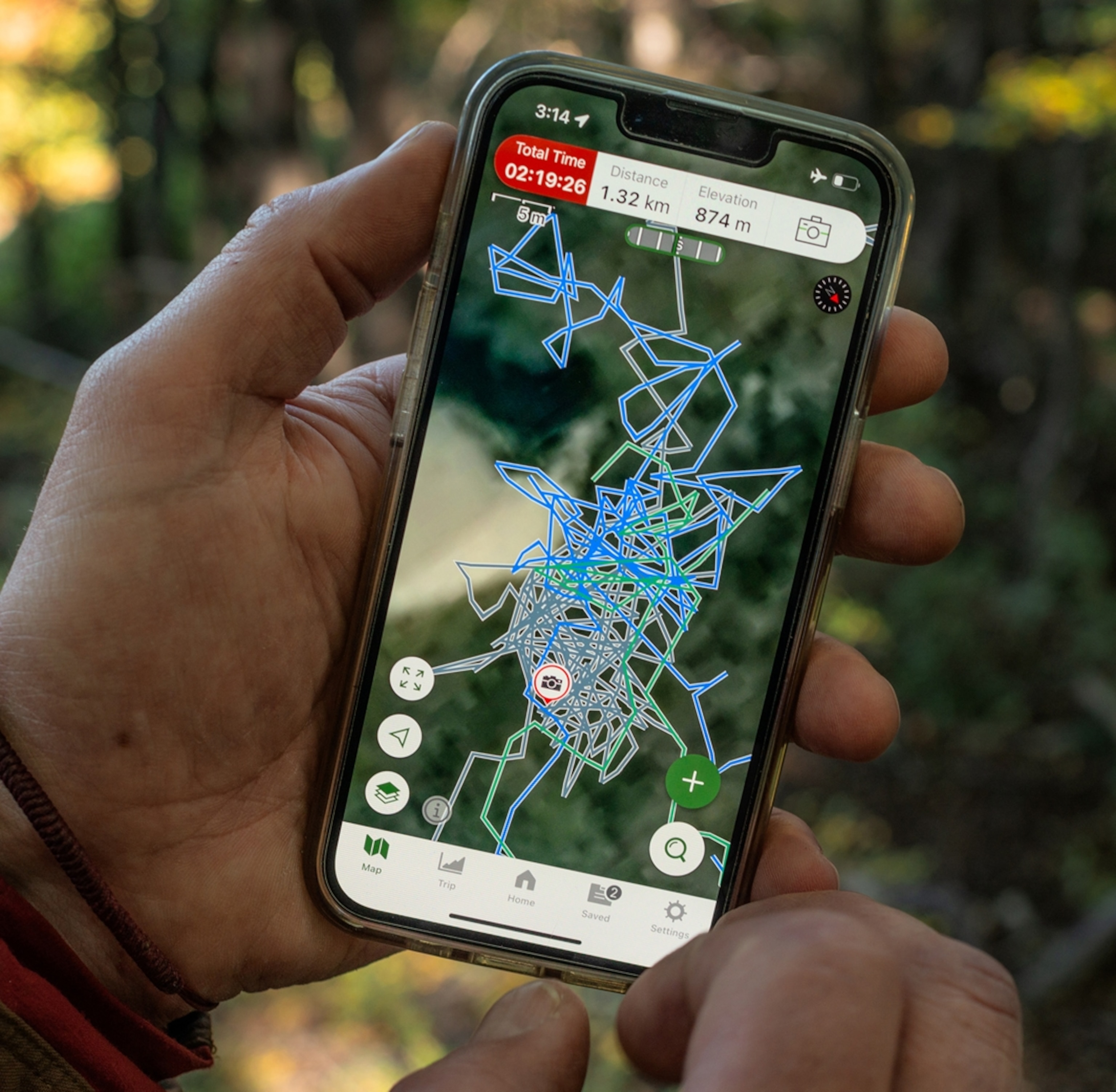 A close up image of someone holding a smartphone showing a gps with lots of lines over it