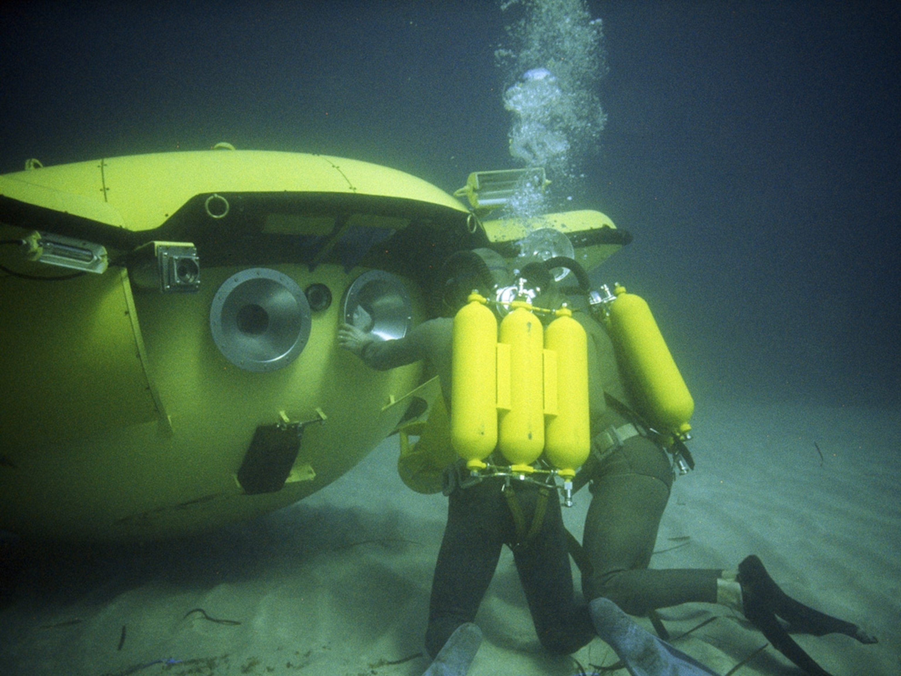 Divers peer into a diving saucer