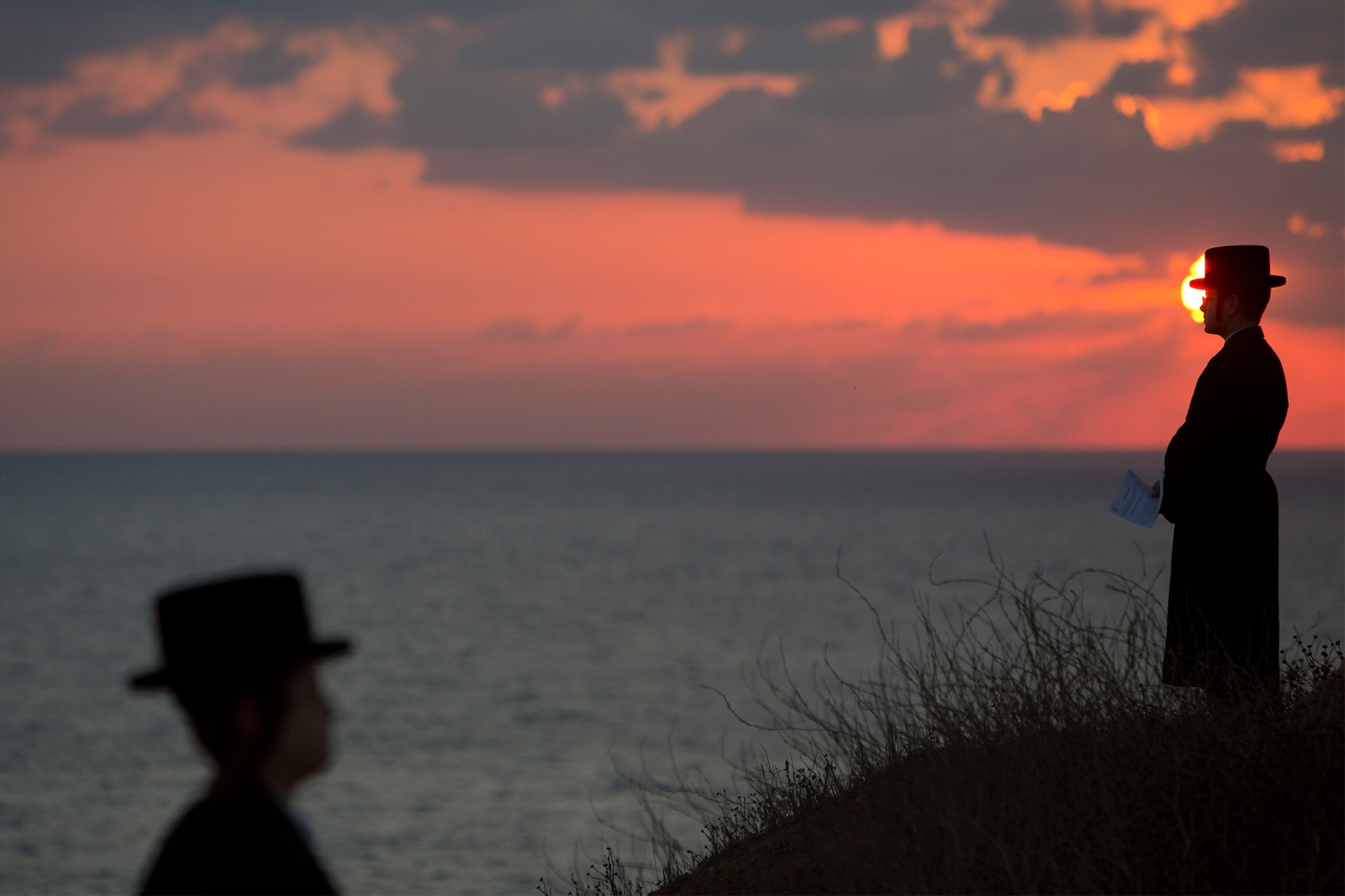 Ultra-Orthodox Jews gathering on a hill overlooking the Mediterranean sea.