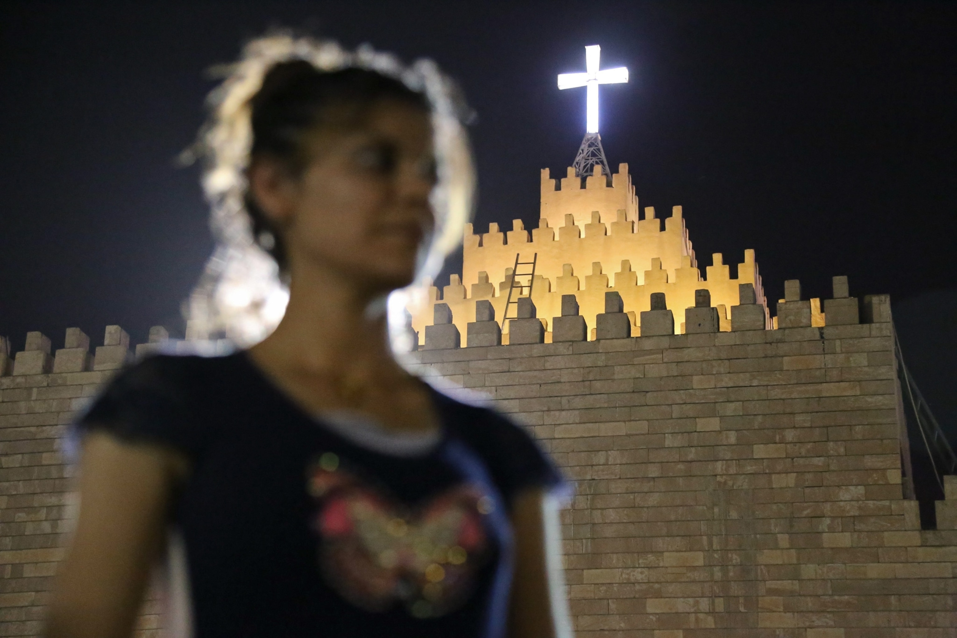 woman kissing a small boy in front of the Mar Tshmony church.