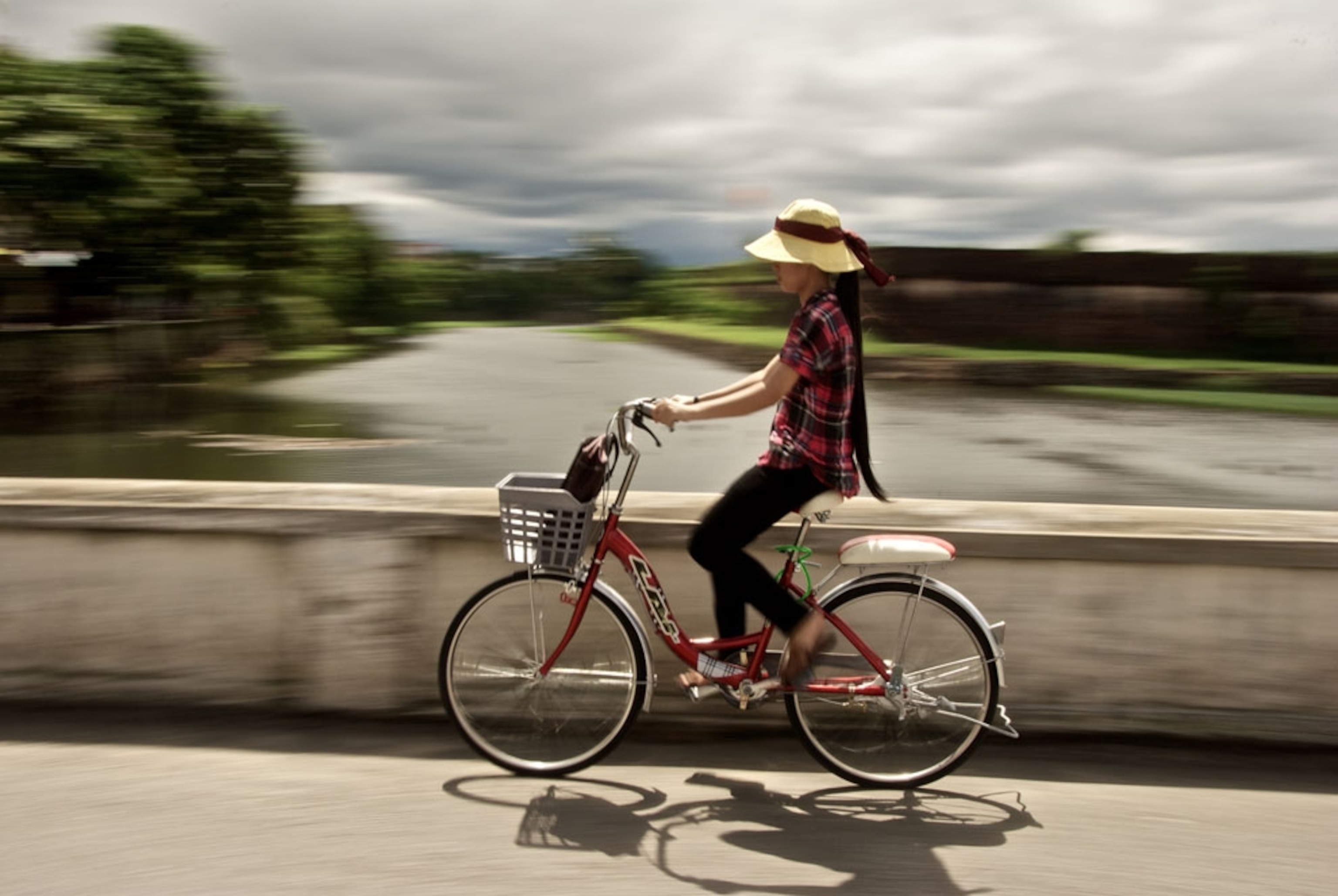 A woman riding a bike near the entrance to the Forbidden City in Hue, Vietnam