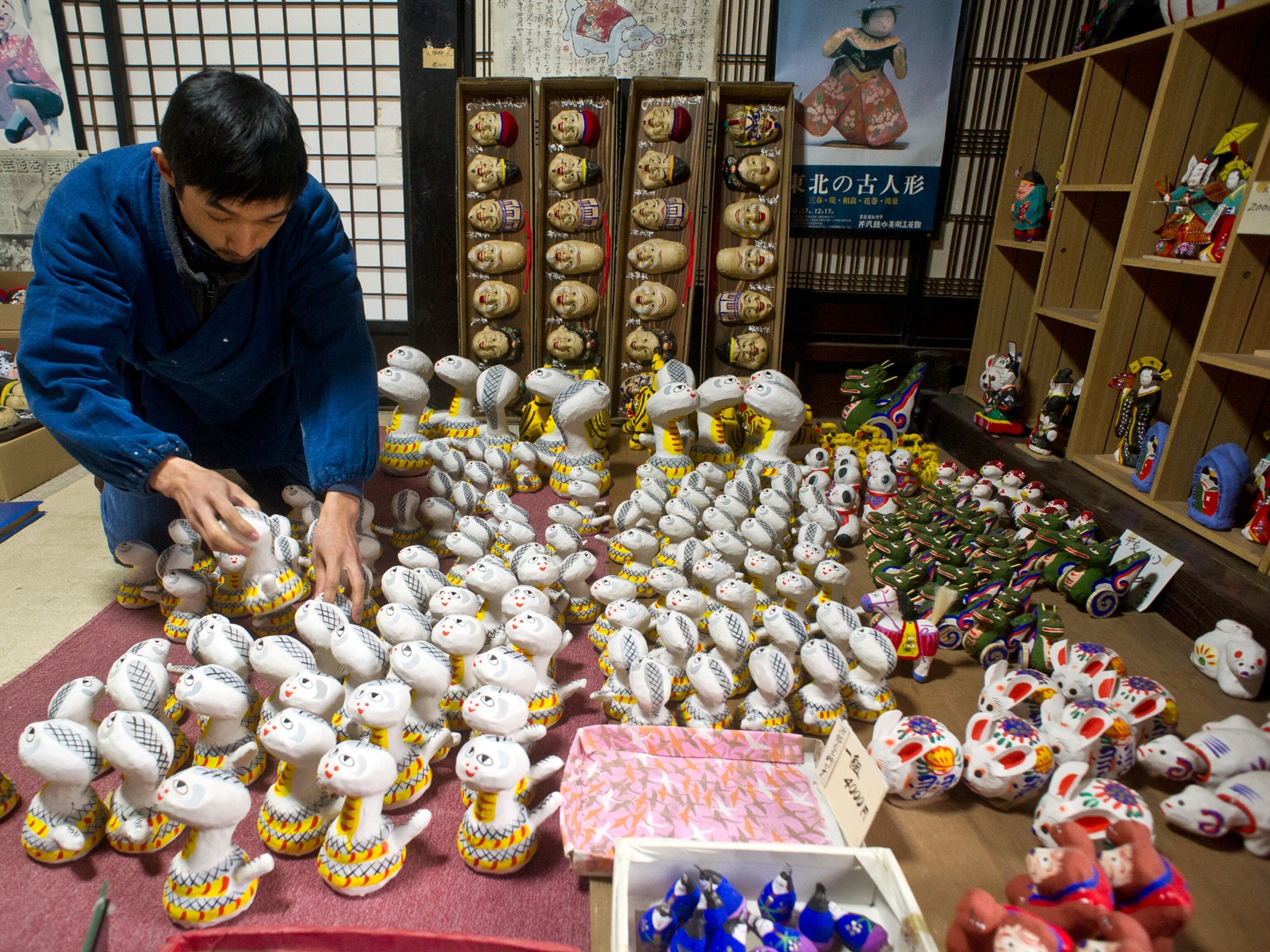 an artist inspecting paper dolls