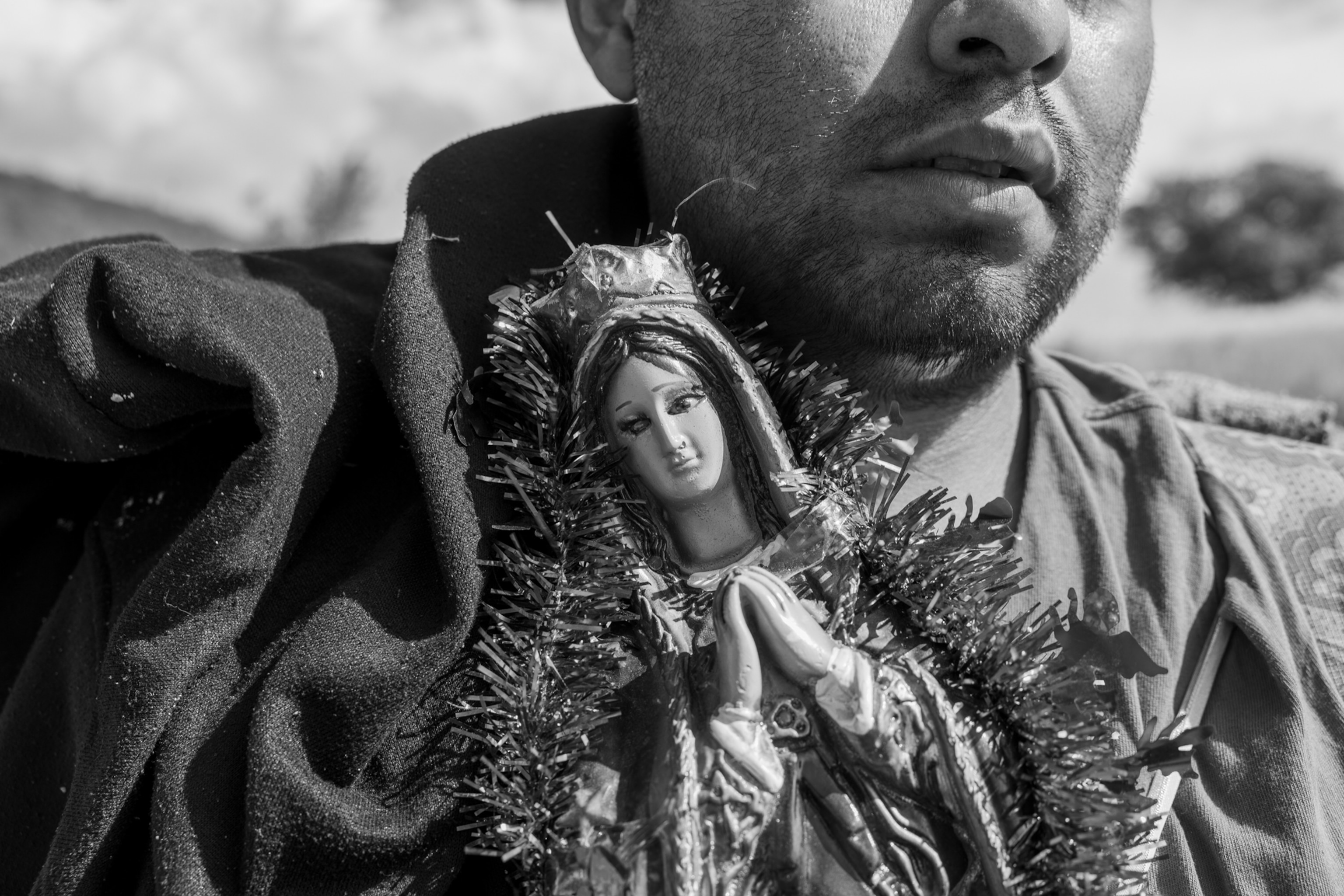 A close up of a statue of a woman that a man is holding.