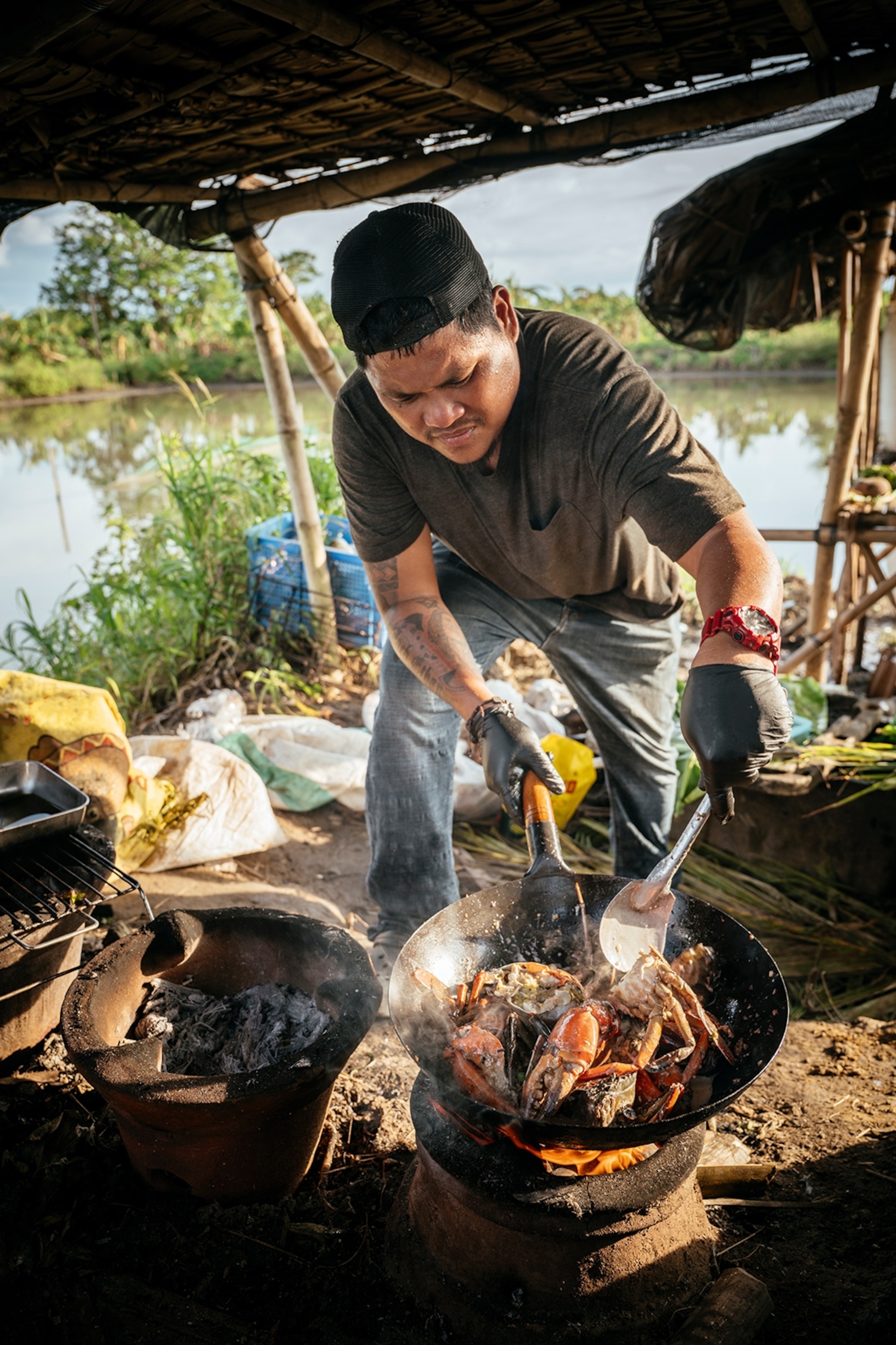 A local chef preparing crabs over an open fire in a wok.
